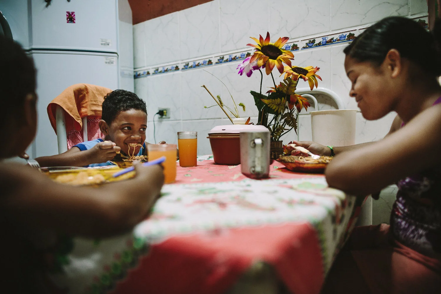 Ever the playful boy, Emidio tries to make his friend laugh with a mouth full of spaghetti during a meal. Each day an "aunt" (family friend--relation) takes care of Emidio and his younger brother between his time at the Compassion Center and School since his mother works until 10pm at night.