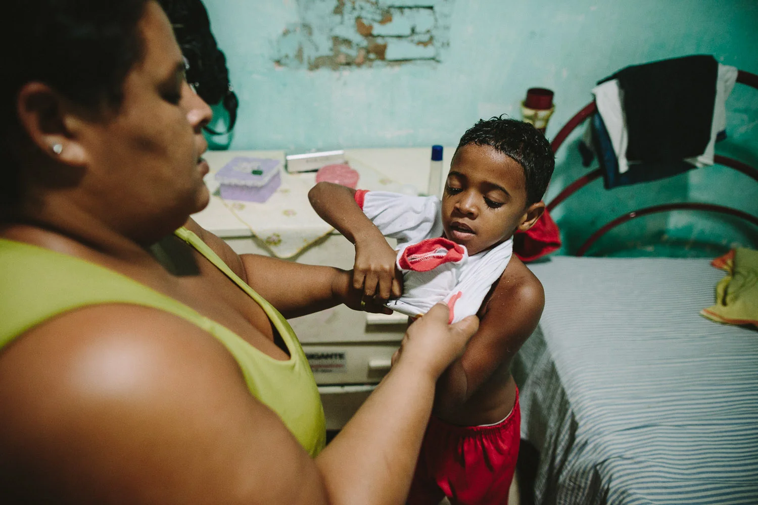His mother's friend gets Emidio ready for school each day. Each day an "aunt" (family friend--relation) takes care of Emidio and his younger brother between his time at the Compassion Center and School since his mother works until 10pm at night.