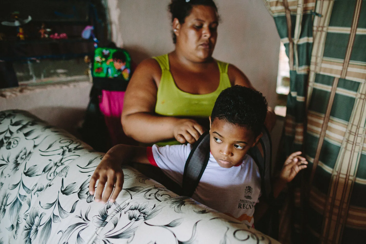 His mother's friend gets Emidio ready for school each day. Each day an "aunt" (family friend--relation) takes care of Emidio and his younger brother between his time at the Compassion Center and School since his mother works until 10pm at night.