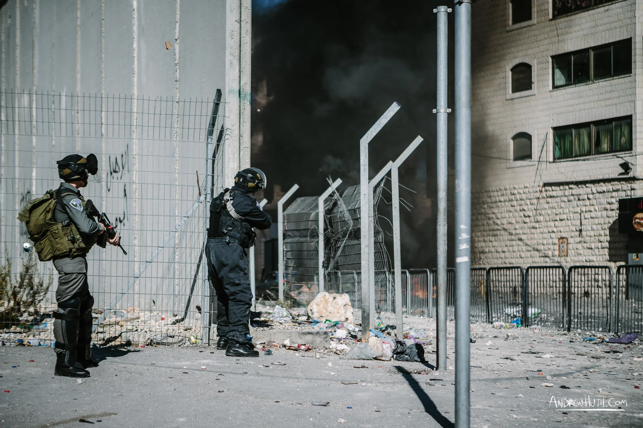 Israeli military using tear gas and guns in an armed conflict with the residents of Shu'afat Refugee Camp. Palestinian youth clash with Israeli military in Shu'afat Refugee Camp in East Jerusalem on Friday, November 7, 2014. The recent, but temporarily total closure of one of Muslim's holiest sites, the Al-Aqsa Mosque, (the first since 1967) and the subsequent limited access for many Muslims to the mosque since has raised tension between Israeli's military and the Arab community.