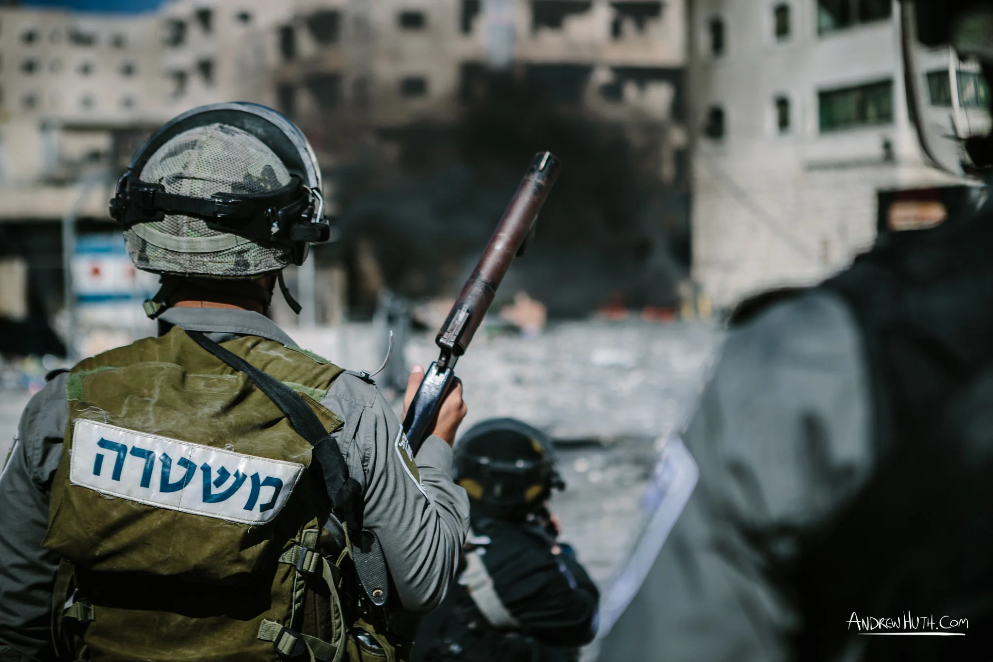 Israeli military using tear gas and guns in an armed conflict with the residents of Shu'afat Refugee Camp. Palestinian youth clash with Israeli military in Shu'afat Refugee Camp in East Jerusalem on Friday, November 7, 2014. The recent, but temporarily total closure of one of Muslim's holiest sites, the Al-Aqsa Mosque, (the first since 1967) and the subsequent limited access for many Muslims to the mosque since has raised tension between Israeli's military and the Arab community.