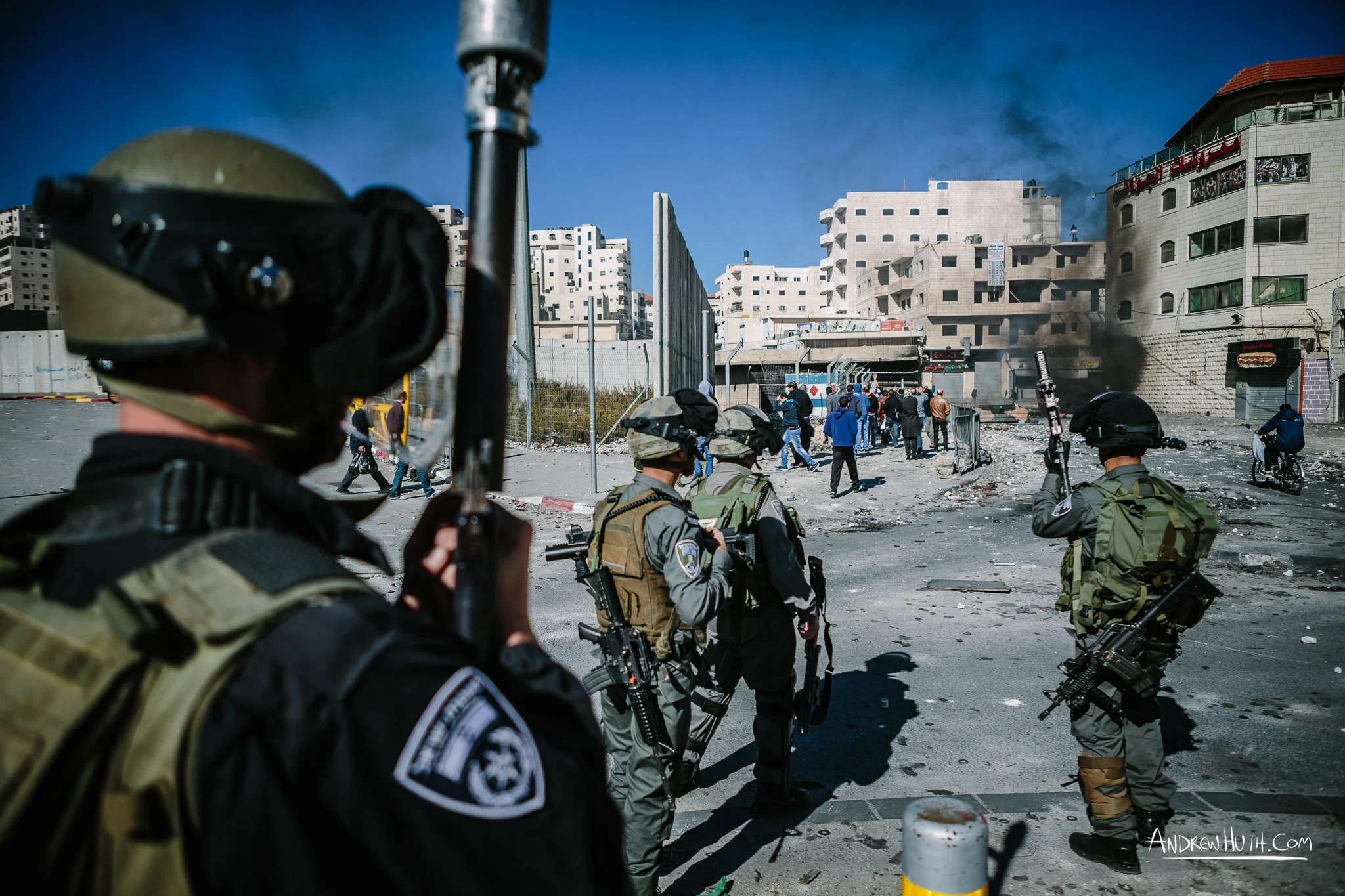 Israeli military using tear gas and guns in an armed conflict with the residents of Shu'afat Refugee Camp. Palestinian youth clash with Israeli military in Shu'afat Refugee Camp in East Jerusalem on Friday, November 7, 2014. The recent, but temporarily total closure of one of Muslim's holiest sites, the Al-Aqsa Mosque, (the first since 1967) and the subsequent limited access for many Muslims to the mosque since has raised tension between Israeli's military and the Arab community.