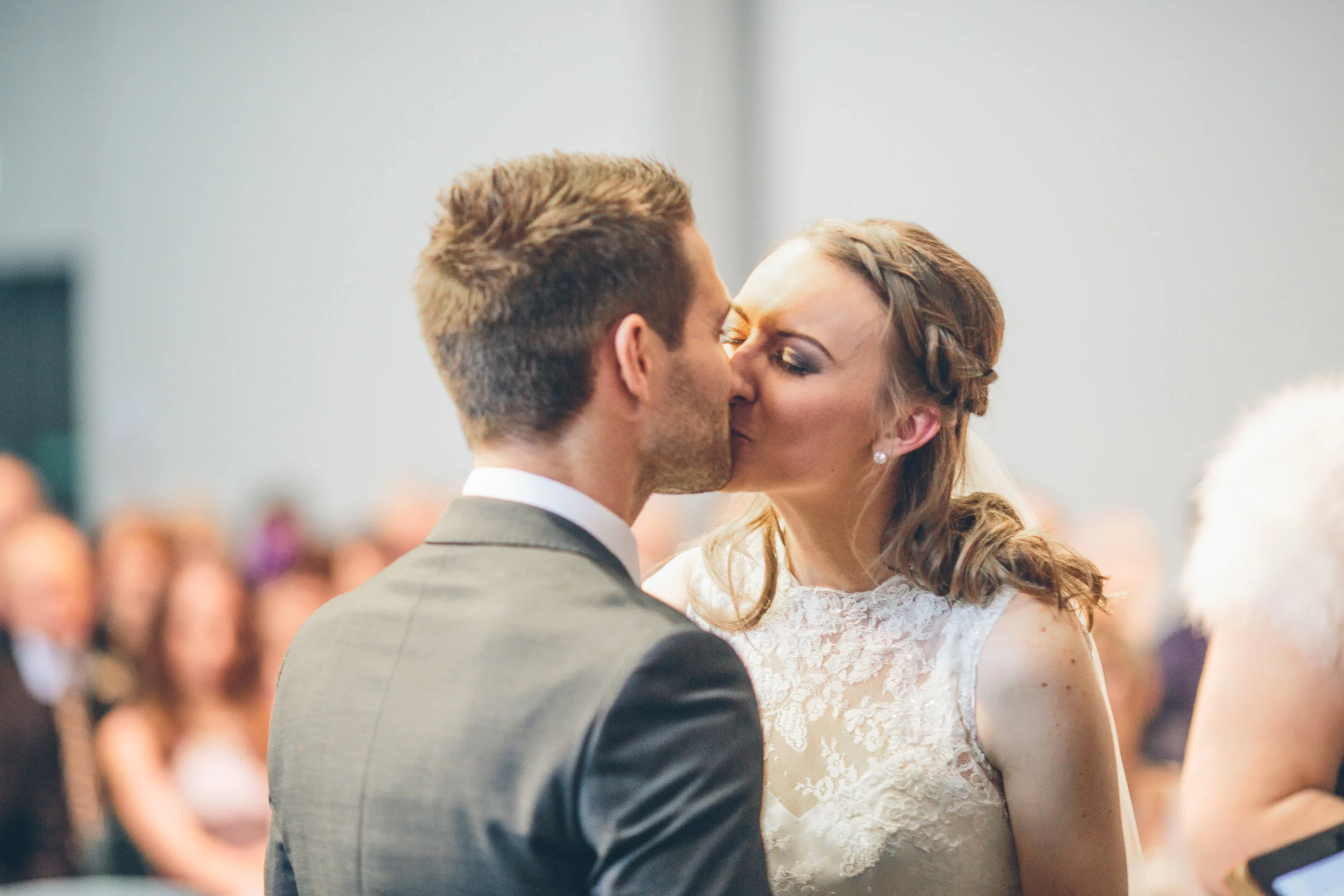 A bride and groom sharing a kiss during their wedding ceremony.