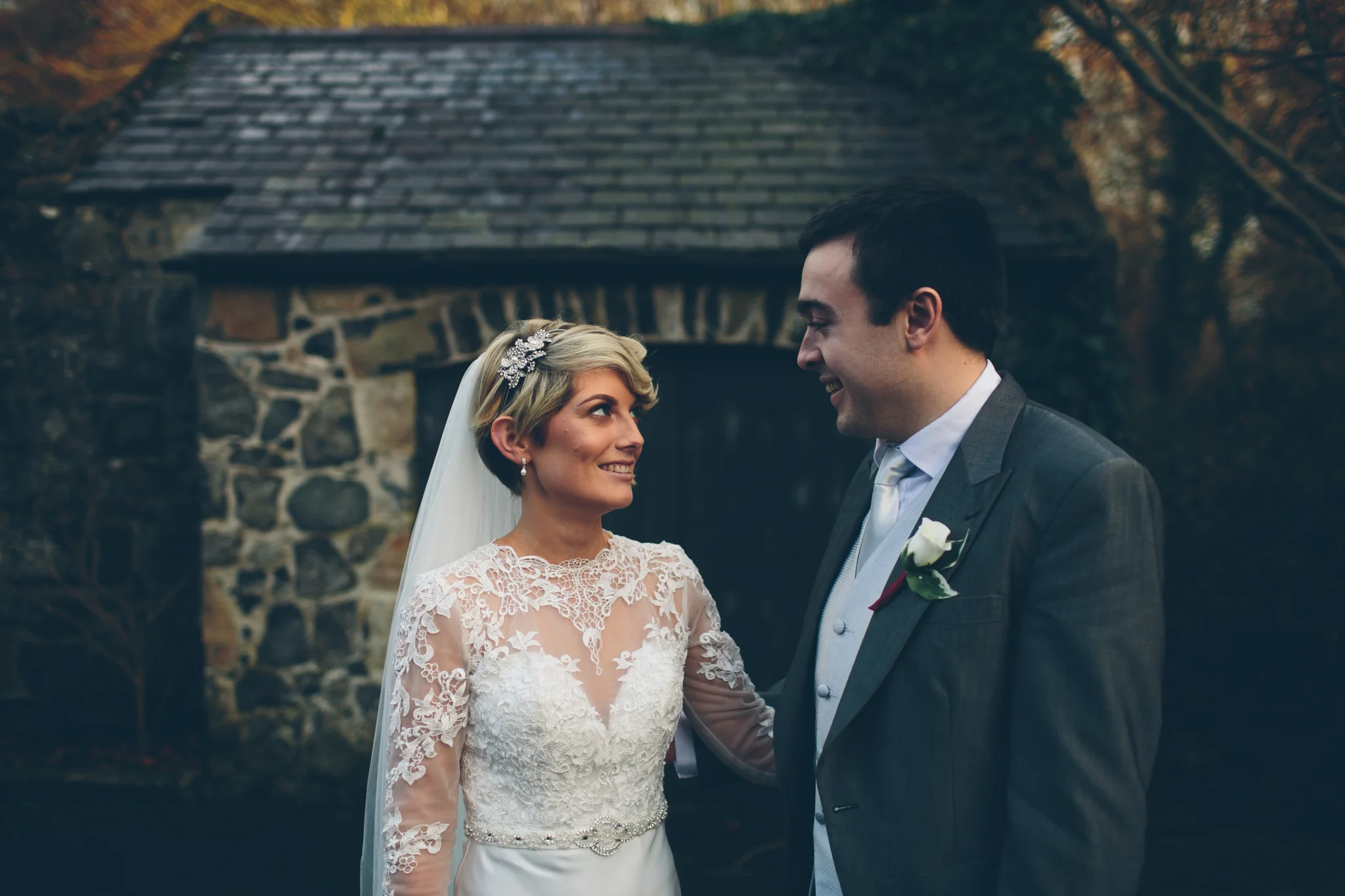 A bride and groom smiling at each other outdoors during their wedding. Dunadry Hotel
