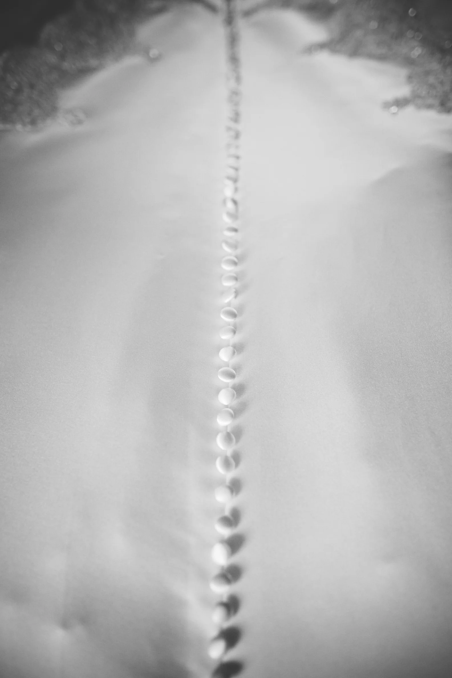 Close-up of water droplets forming a line on a flat surface, with ripples at the top and bottom, viewed from above.