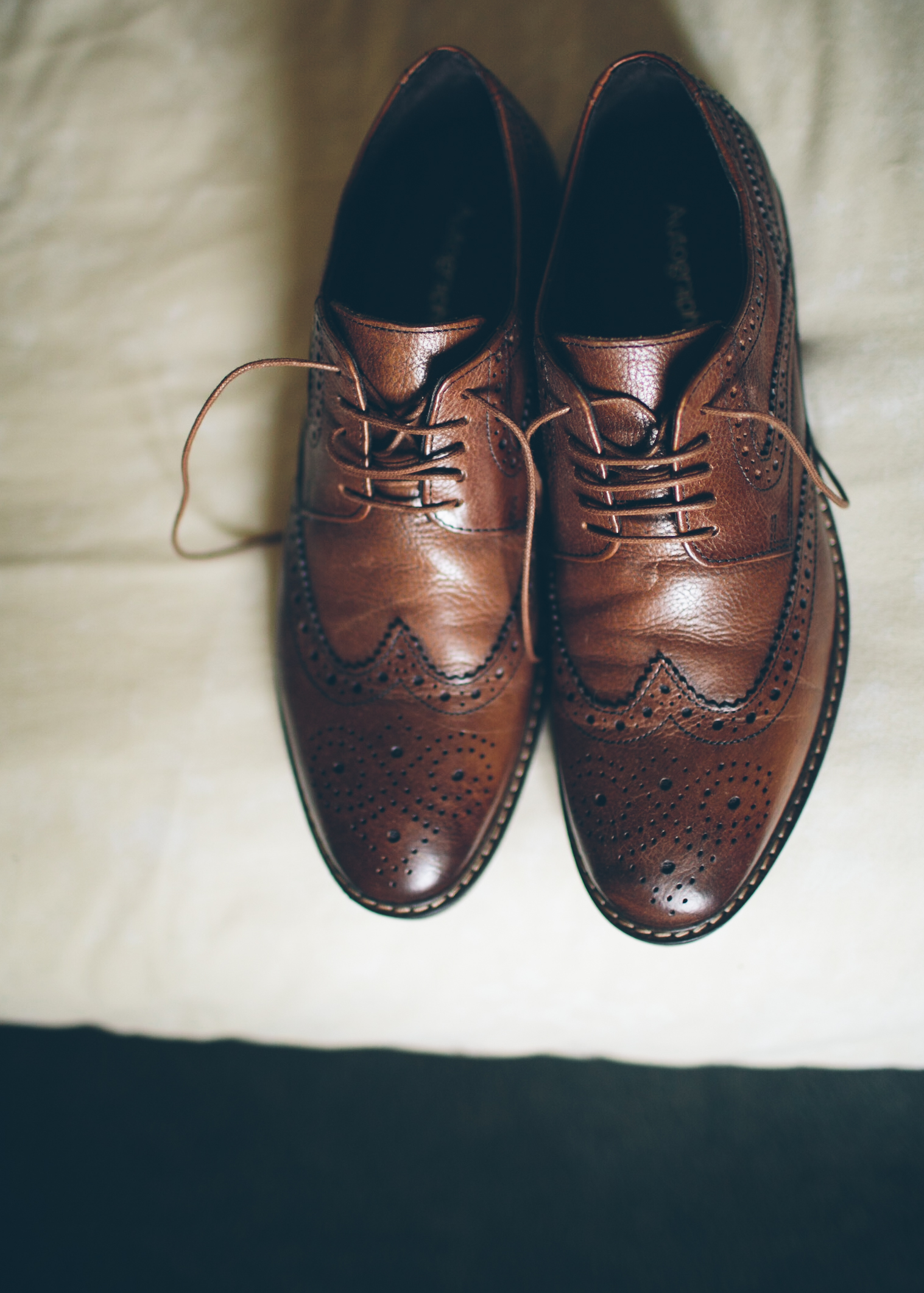 Brown leather brogue shoes on a light-colored surface.