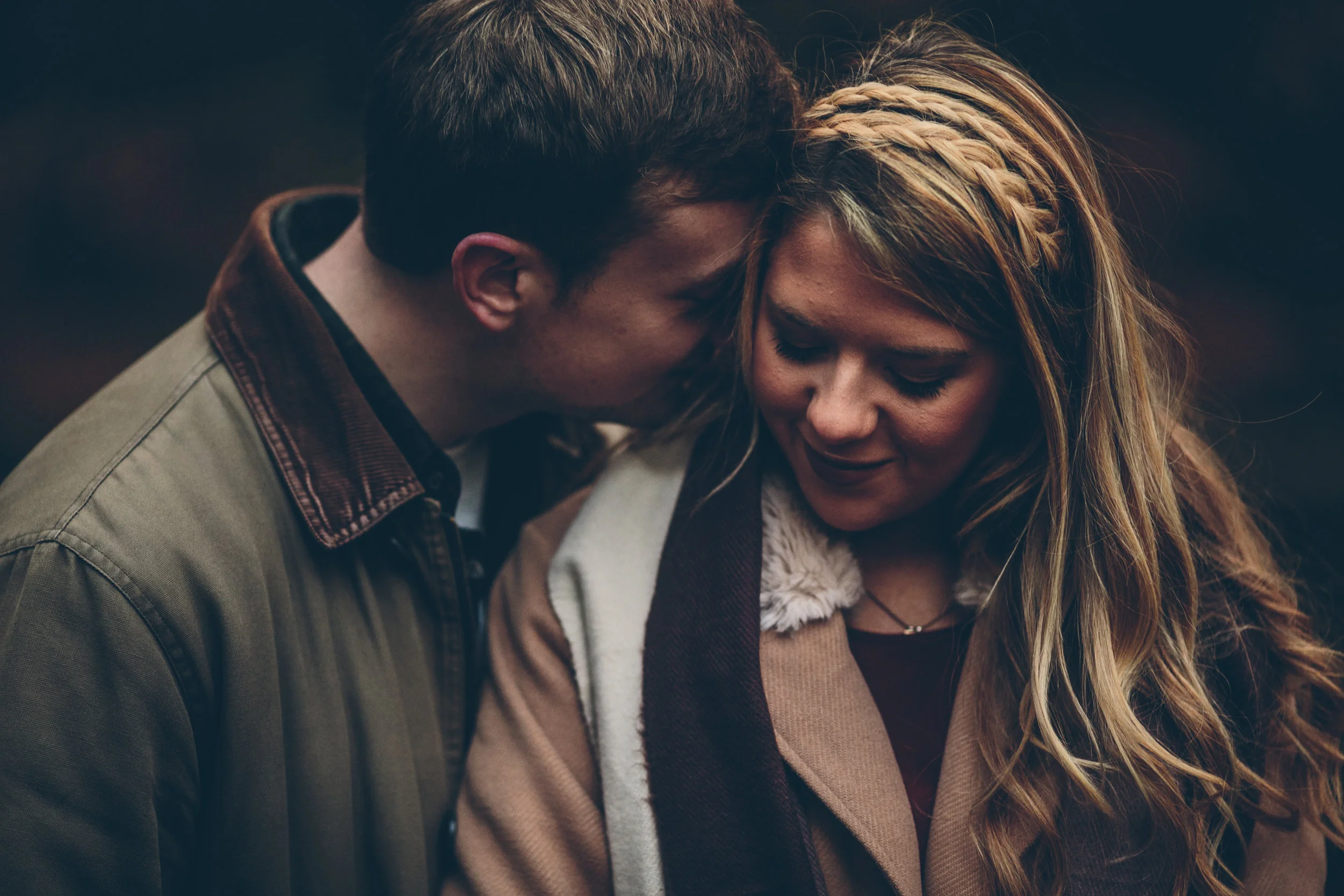 A man and woman share a close, intimate moment with their foreheads touching and eyes closed.
