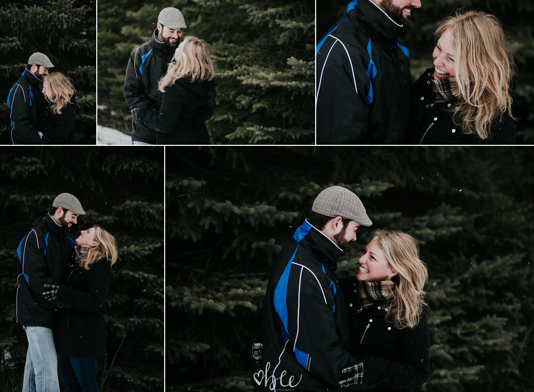 engaged couple snuggling outside in winter with dog