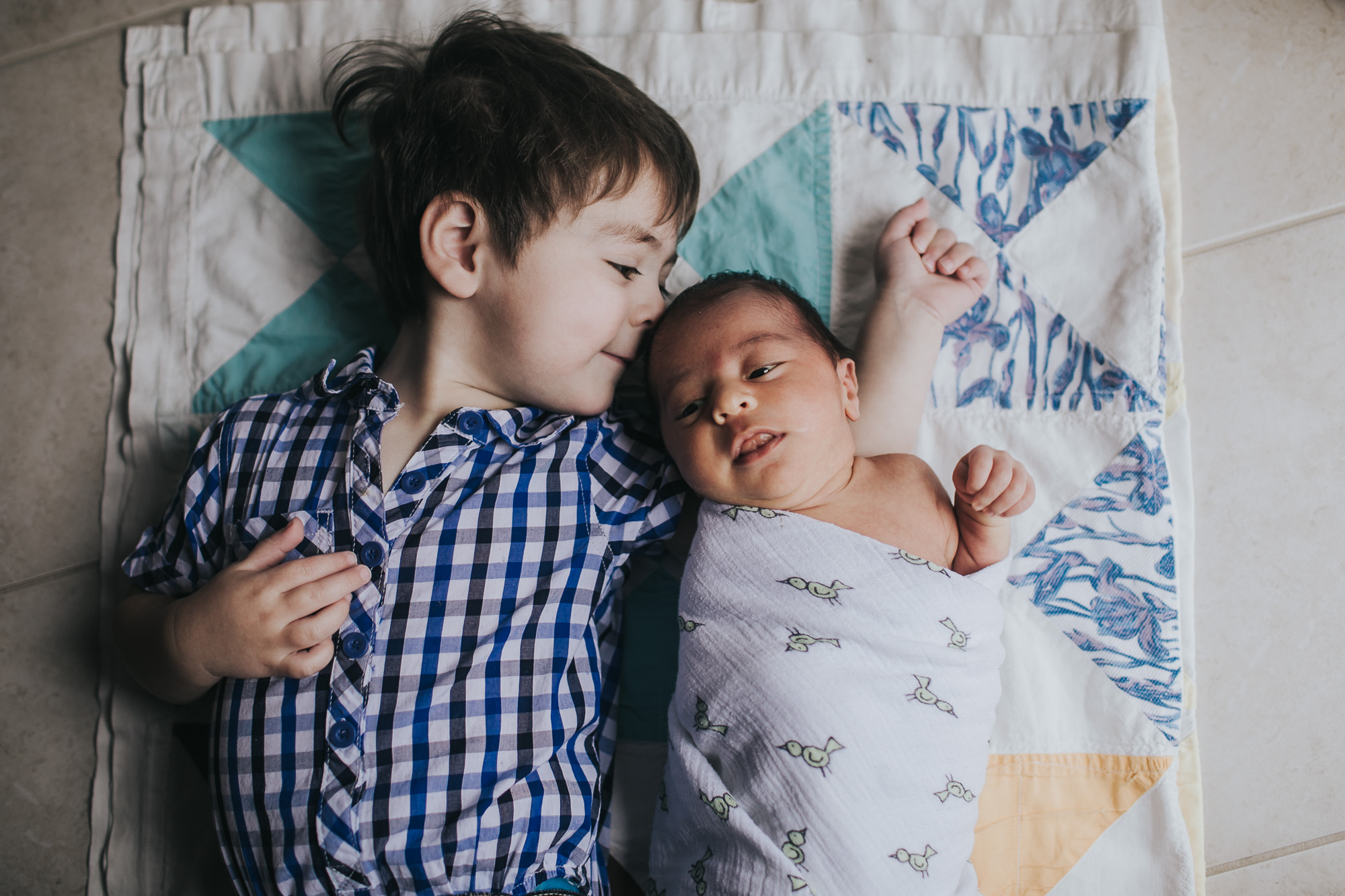 big brother laying with baby brother