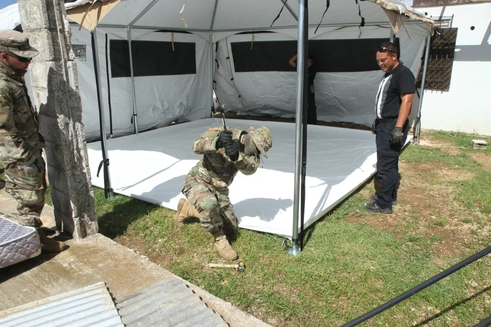 U.S. Army Spc. John Blas, a Soldier with the 797th Engineer Company, 9th Mission Support Command, currently assigned to Joint Task Group-Saipan, Task Force-West, stakes a metal rod into the ground to secure Celina’s Humanitarian Tent, which will be used as temporary shelter for Saipan residents impacted by Typhoon Yutu, Nov. 9, 2018. (U.S. Marine Corps video by Angelo Garavito/Released)