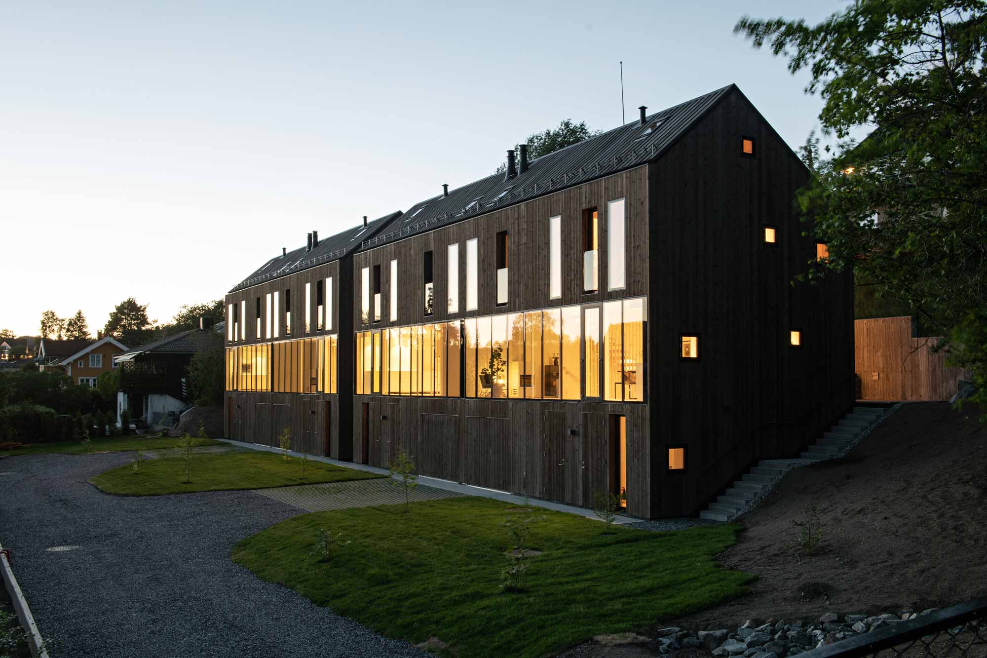 The compact dwelling provides a close contact with the surrounding nature. The ground floor hosts the main access to the house, while the first floor accommodates family activities with glazed walls providing views and light.