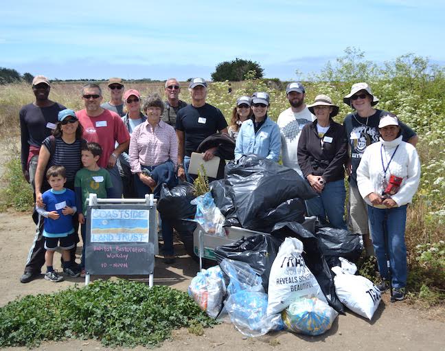 Volunteers proudly display all the trash picked up after a workday.