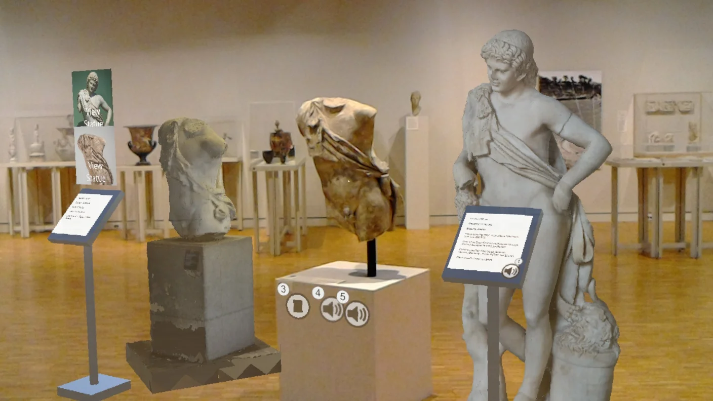 A view through the HoloLens of the final design in the museum. The center statue is physically in the space, while the others are virtual models.