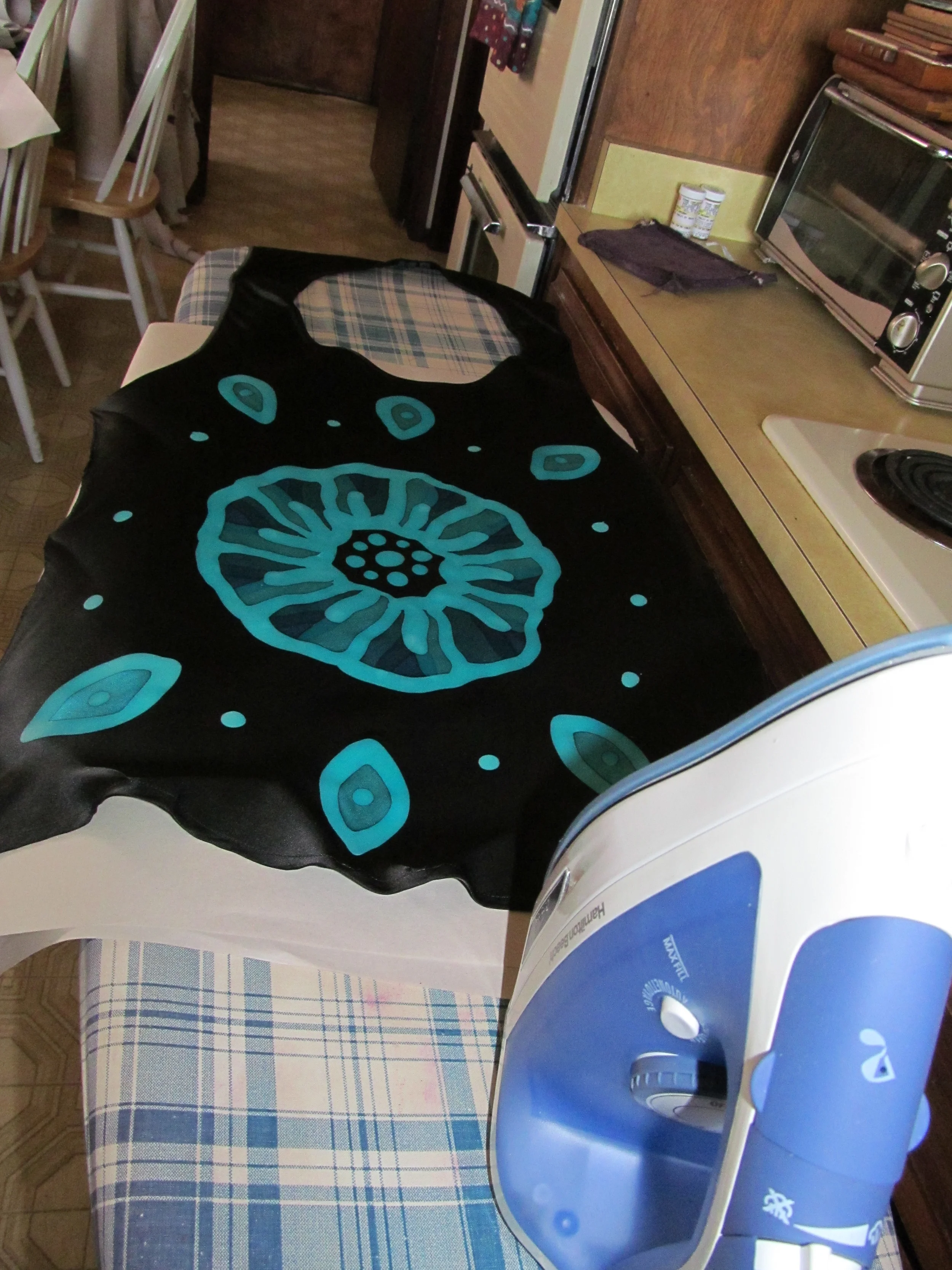 Here the silk is placed on the blank newsprint, & two more layers of newsprint are added on top of it to start ironing.