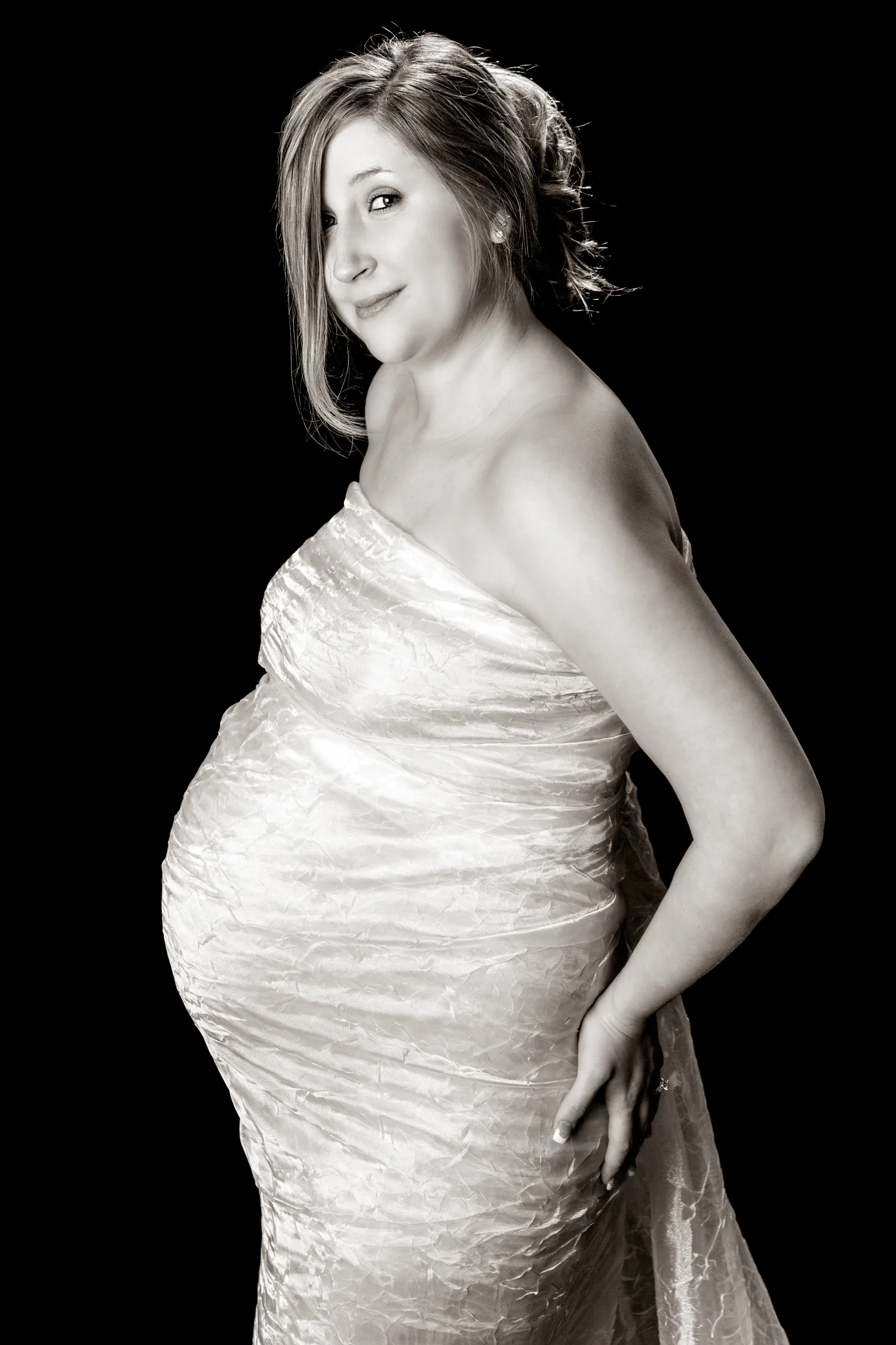 Black and White Maternity Photo of beautiful young pregnant woman wrapped in flowy material.