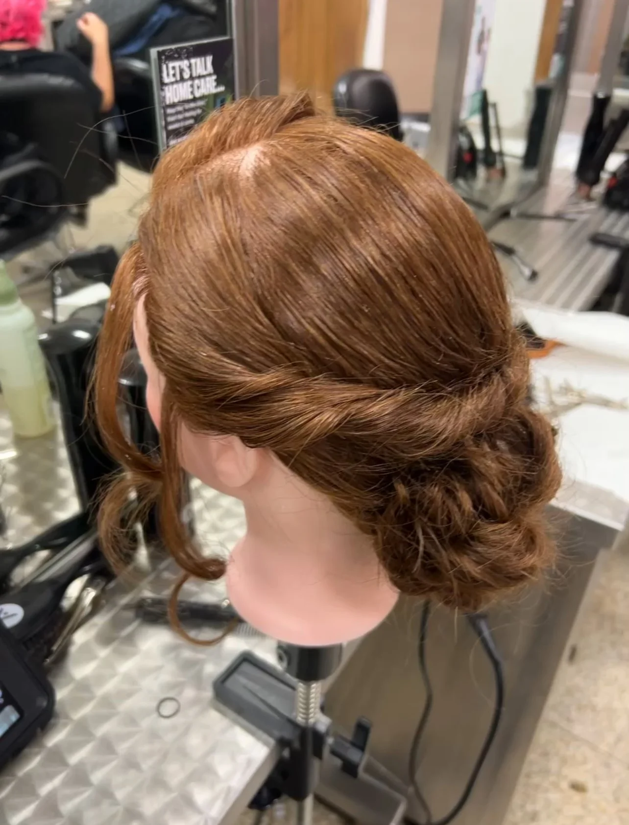 Low braided bun updo on mannequin head