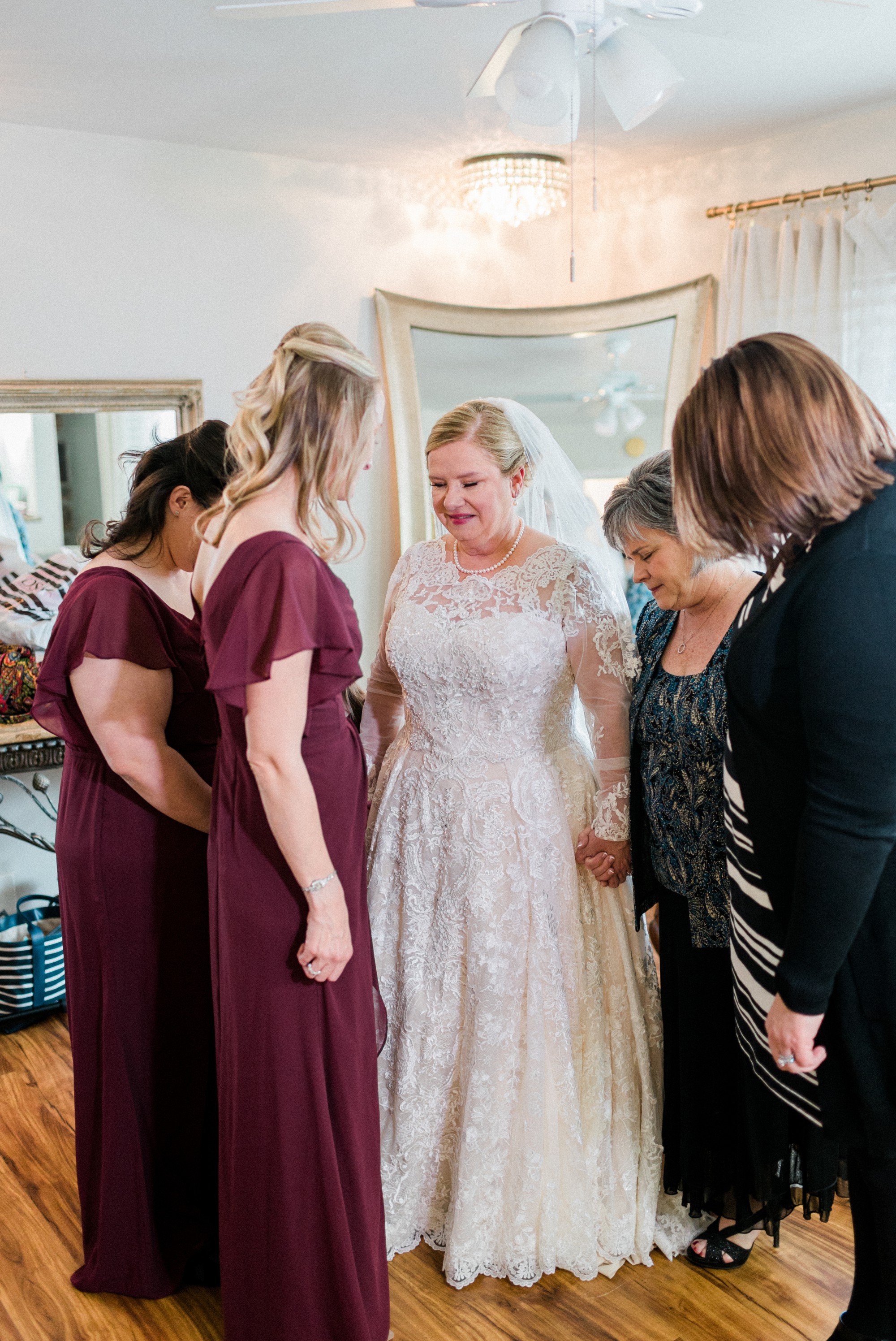 bridesmaids praying around bride