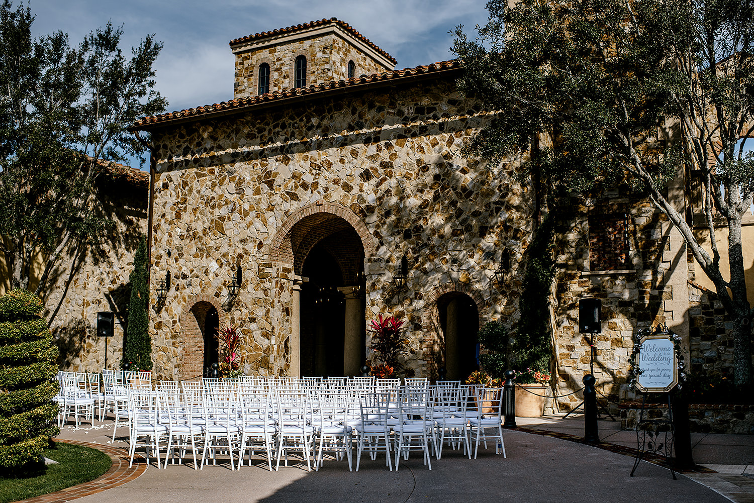 Italian Inspired wedding ceremony space with beautiful white chairs.