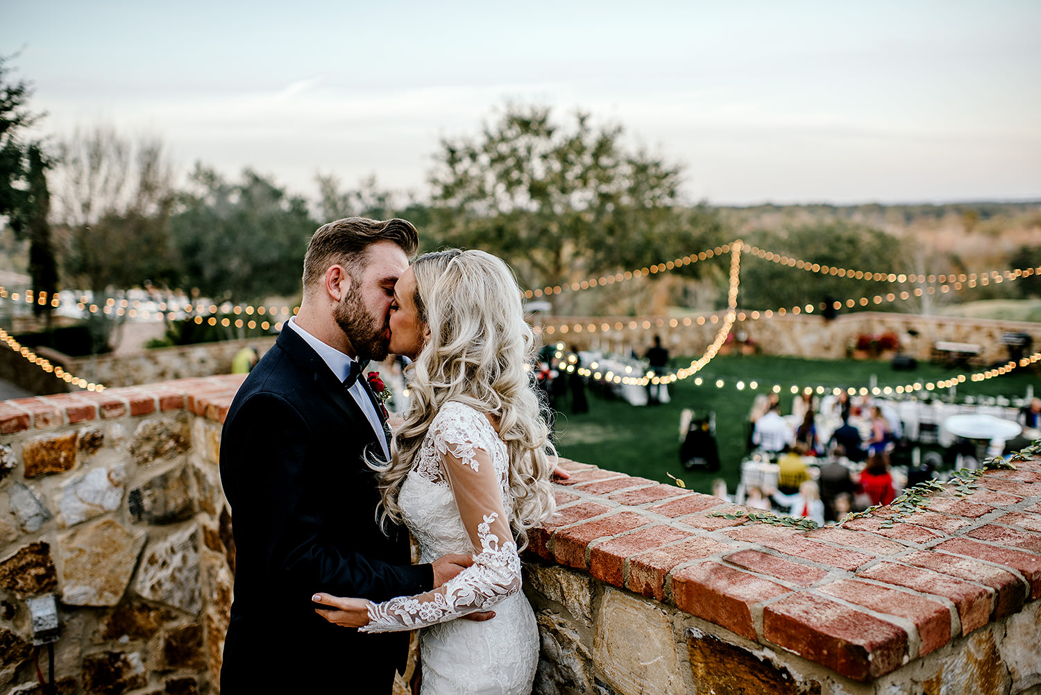 Bride and groom sharing a kiss overlooking the wedding reception at Bella Collina Florida