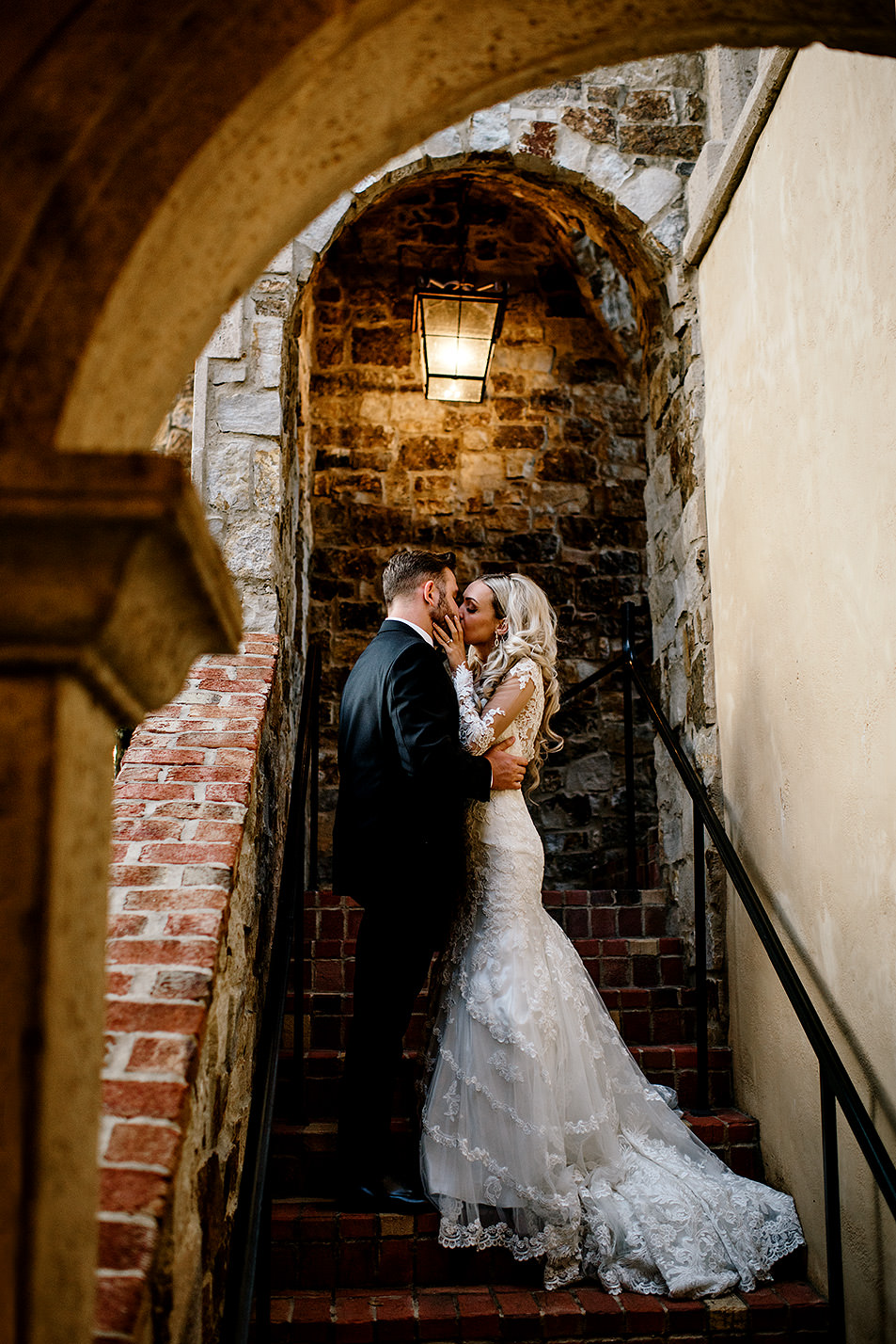 Portrait of a bride and groom kissing under a beautiful italian inspired stairwell at Bella Collina Florida.