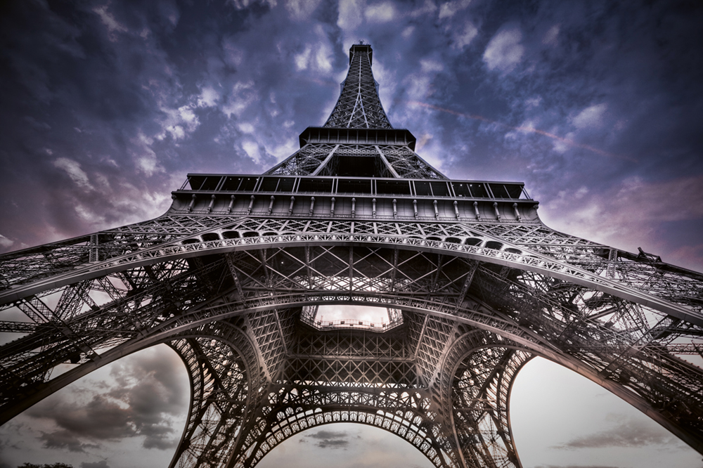 Neben anderen Verschönerungen verdankt der Turm seine kühn geschwungenen Bögen dem Architekten Charles Léon Stephen Sauvestre. Er wurde von Gustave Eiffel damit beauftragt, den ursprünglichen Entwurf des Turmes wettbewerbsfähiger zu machen Photo © 2019 Serge Ramelli. All rights reserved.