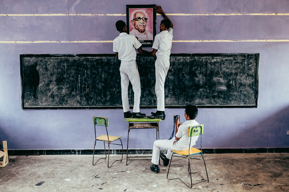 Teenager hängen während einer Mathematikstunde in einer Uferstadt im Süden Sri Lankas ein Bild des verstorbenen sri-lankischen Anwalts Kannangara auf Photo © 2019 Pie Aerts. All rights reserved.