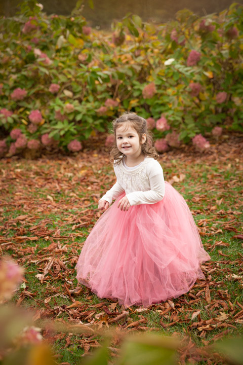 This girl was crazy over tutus, so we chose to put her in a floor length pink tutu, and place her amidst the hydrangea bushes. The framing of the branches creates a feel that the viewer is catching a genuine moment while this girl is in her own world, dancing among the flower maze.