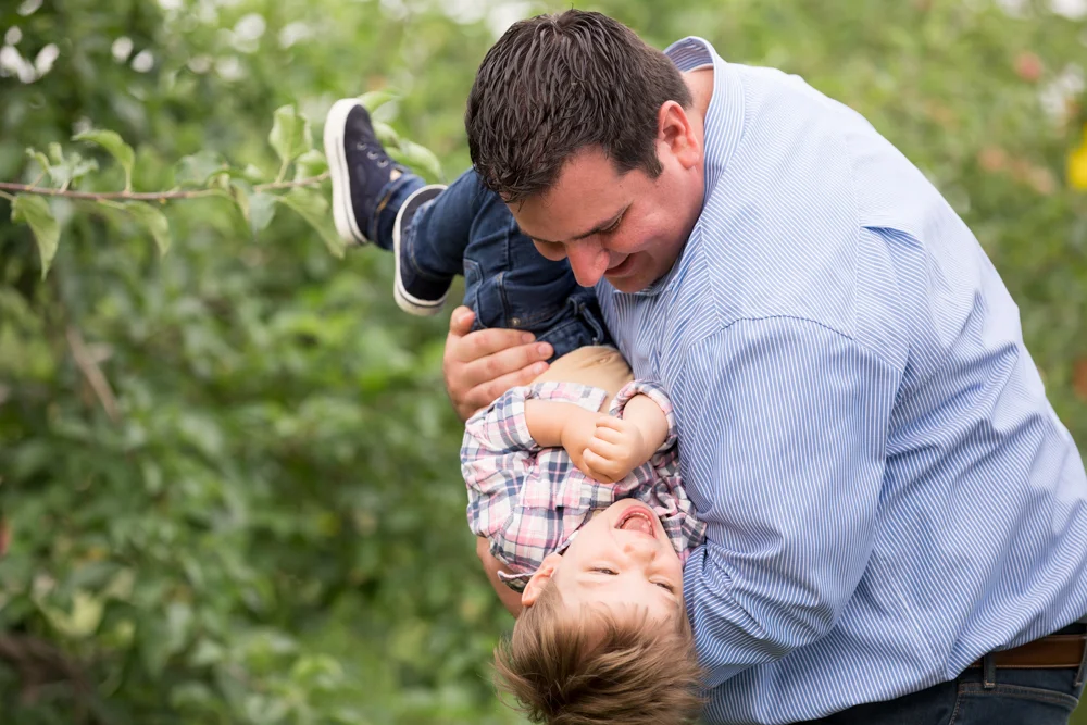 dad-son-kid-silly-tickling-spring-orchard.jpg
