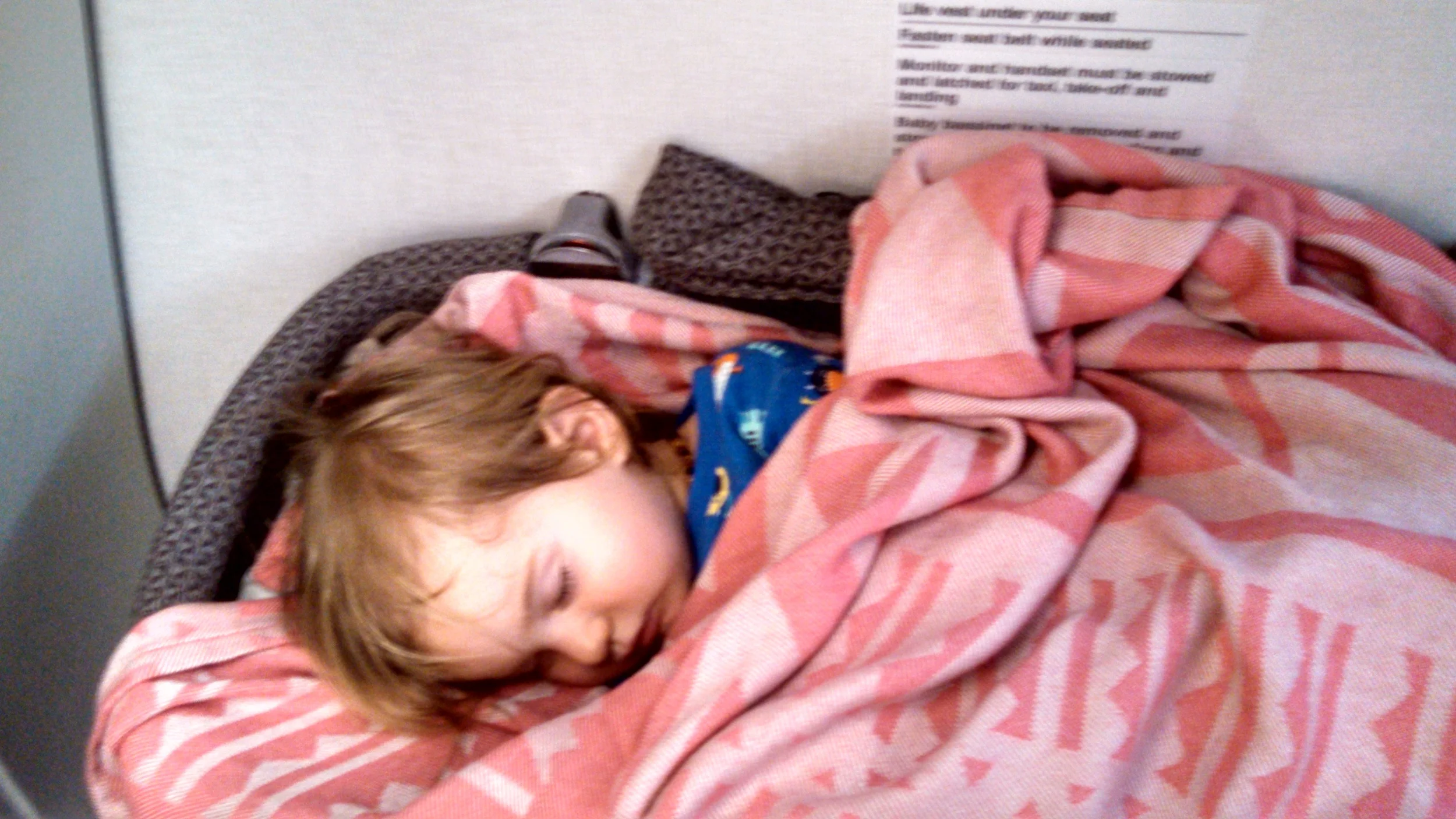 The neat sleeping situation on Air Fiji- in the wall basinet over our legs, Noah actually slept a great part of the way. April 2015.