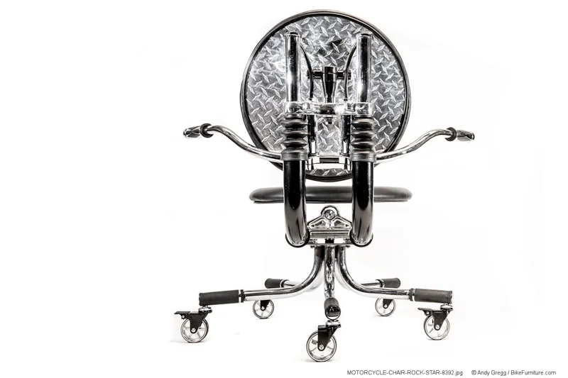 This shows a back view of a chair that uses polished aluminum diamond plate cushion backing, and the use of those black rubber fork boots. Note that the chrome tubes on chairs made in the future would not extend as far as the ones on this chair.
