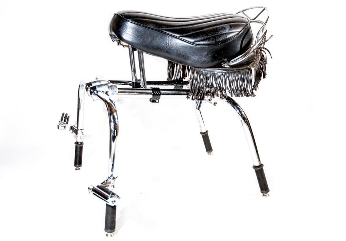 This recent  commission for an &lsquo;office chair&rsquo; showcases a motorcycle seat provided by the client. 
Constructed from repurposed motorcycle parts, the chair features fork tubes, triple trees, and modified engine guards. The design seeks to 