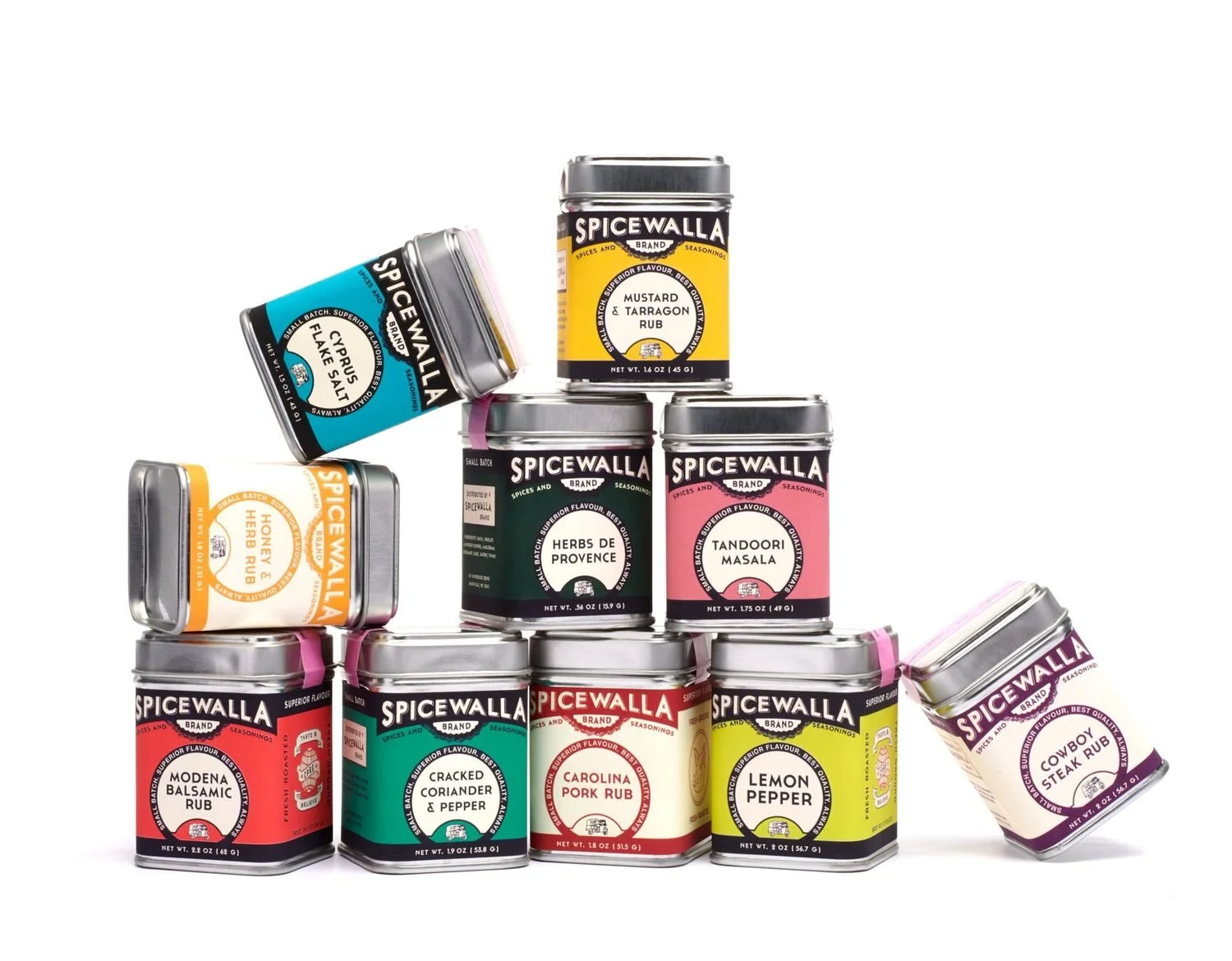 Colorful spice tins stacked in a pyramid with a few tumbling off the sides.