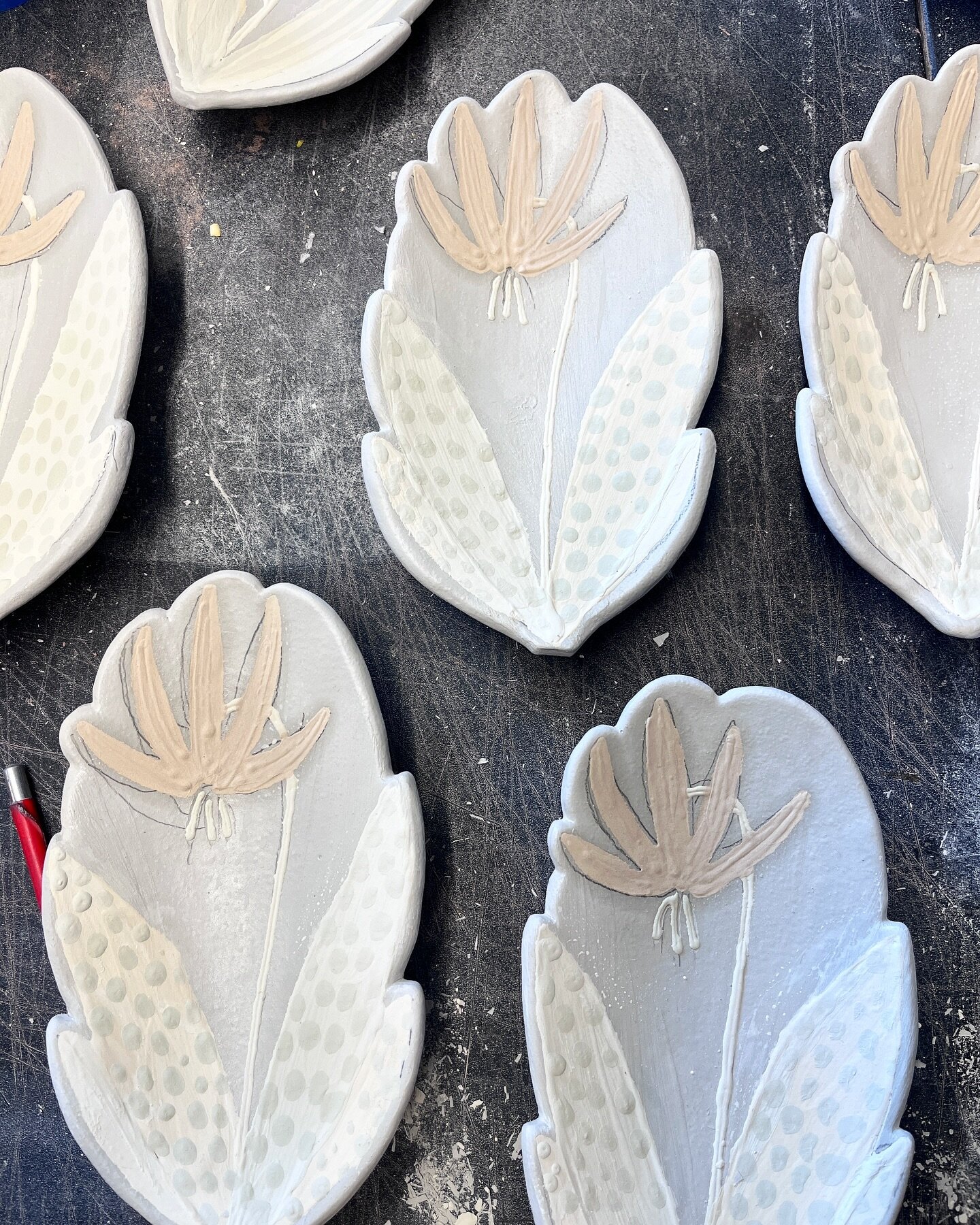 Here they are filled with the multiple cone six glazes before firing. These are fawn lily or trout lily wildflower spoonrests headed for the kiln. This is a wildflower that will be present in the wooded areas soon, if you look carefully you will see 