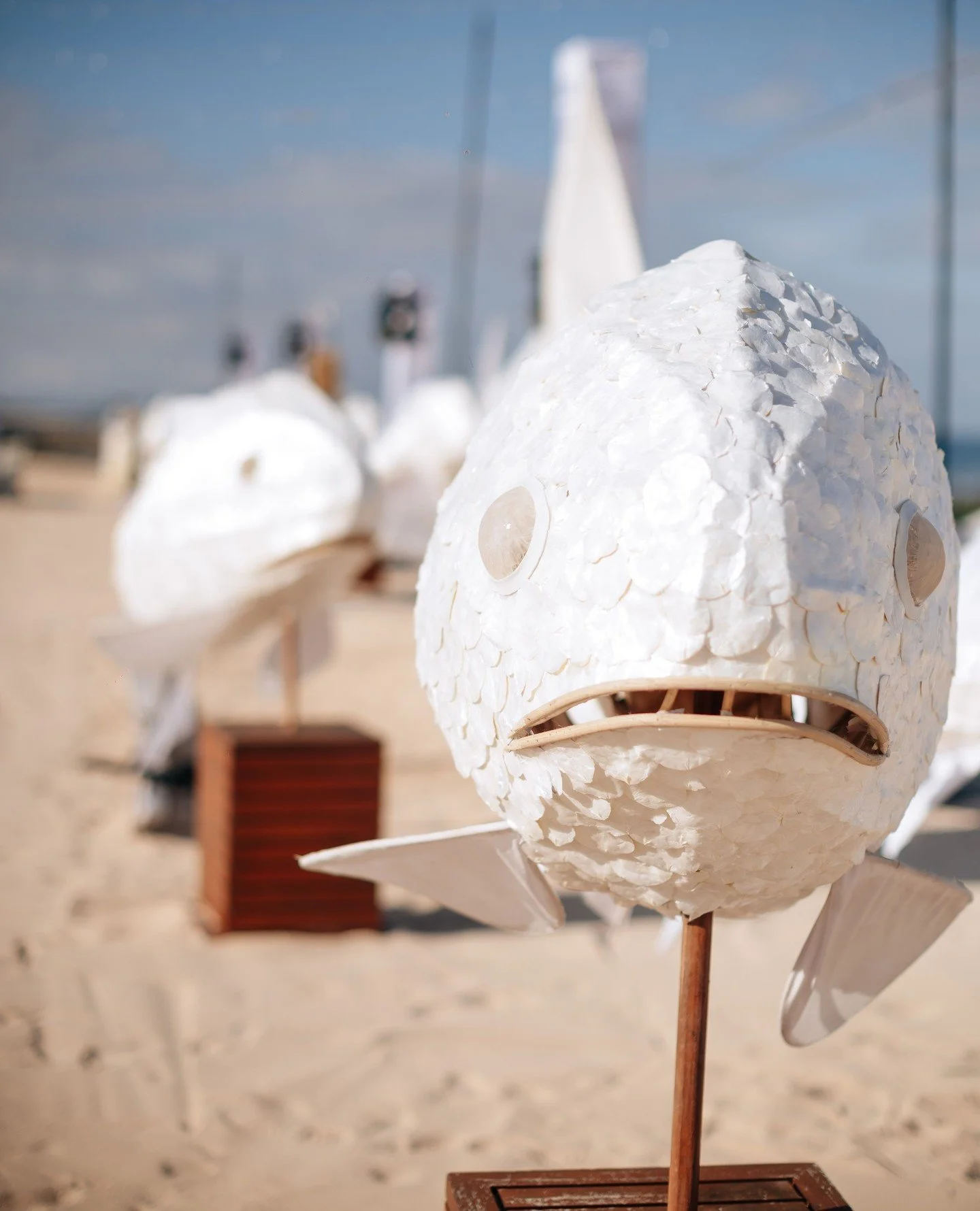 Fish lanterns that magically turned into props for dancers to carry. From decor to performance. Covered in thin slices of shell for a shimmer in the light.