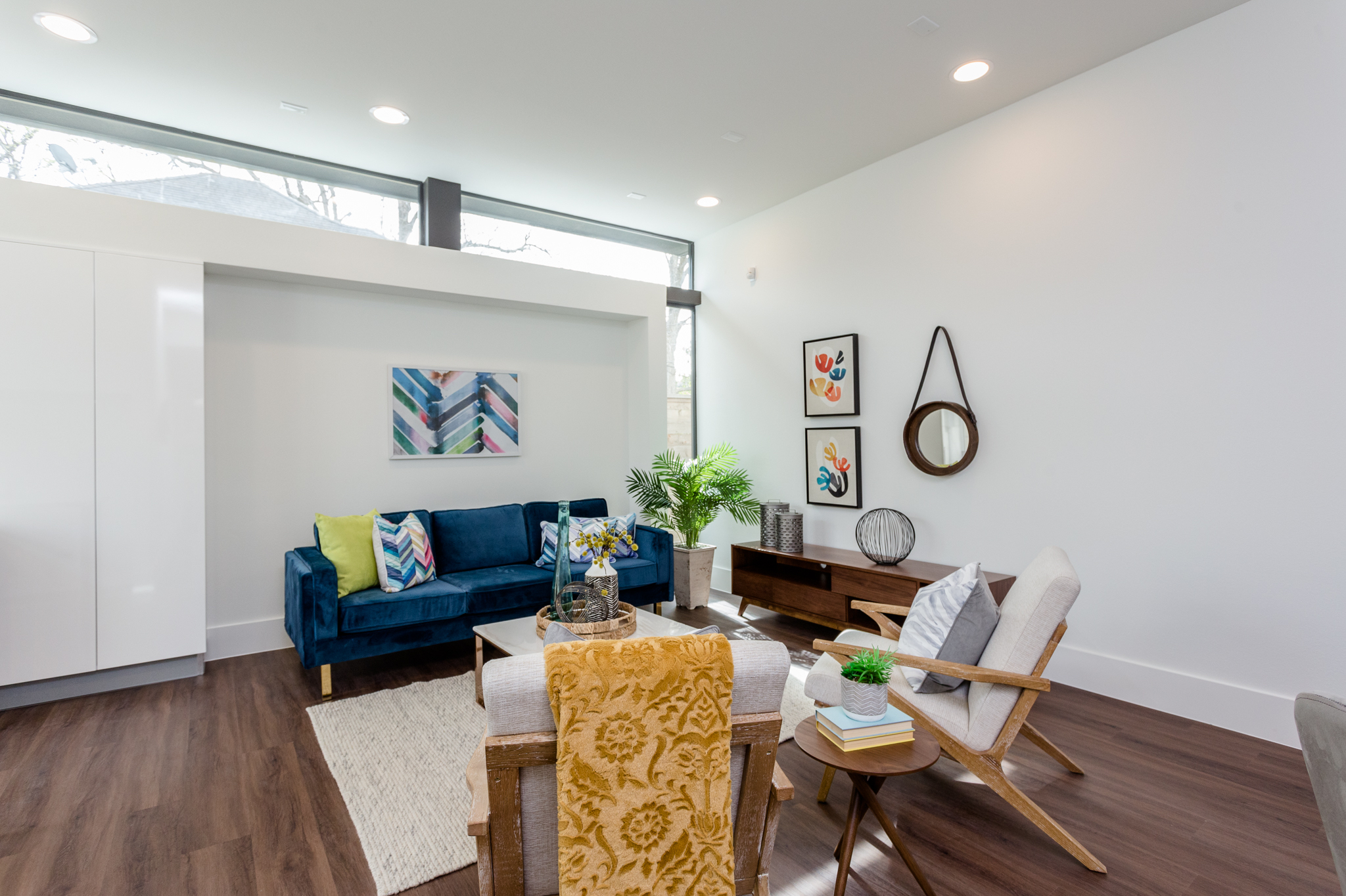 The thoughtfully designed first-floor living area features an elegant recess perfect for audiovisual equipment and carefully positioned clerestory windows that take advantage of 10' ceilings to maximize both wall space and natural light.