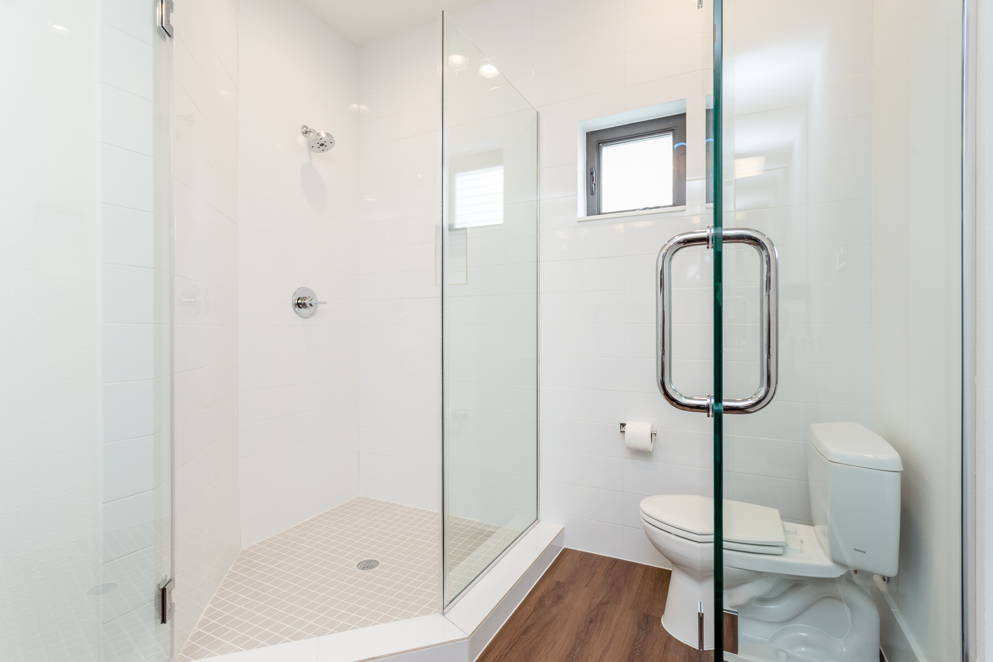 A frameless glass enclosure separates the shower from the water closet. Glass will be frosted to allow for enhanced privacy.