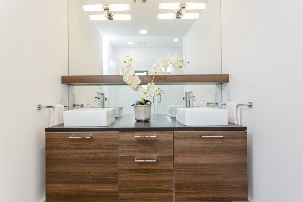  The sleek, floating cabinet and large, sparkling mirror bring a sense of sophistication and openness to the bathroom. 