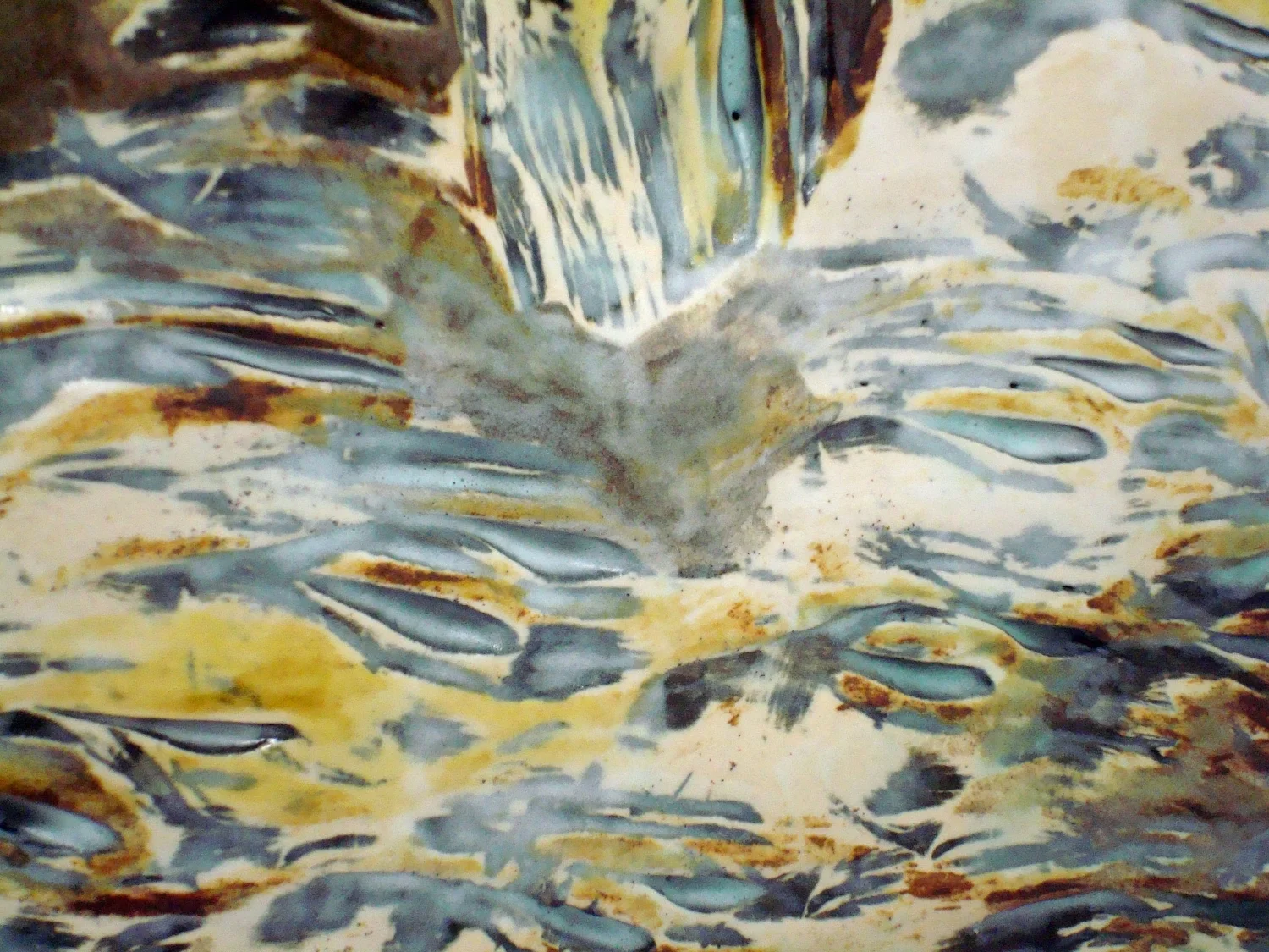Fired surface of pot showing multiple slips and glazes.