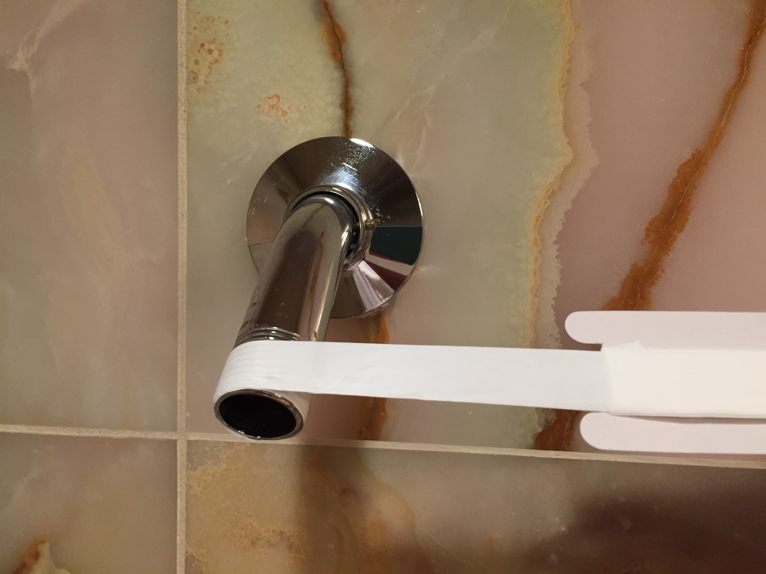 Wrap plumber's tape (thread seal tape) around the shower arm to create a watertight seal