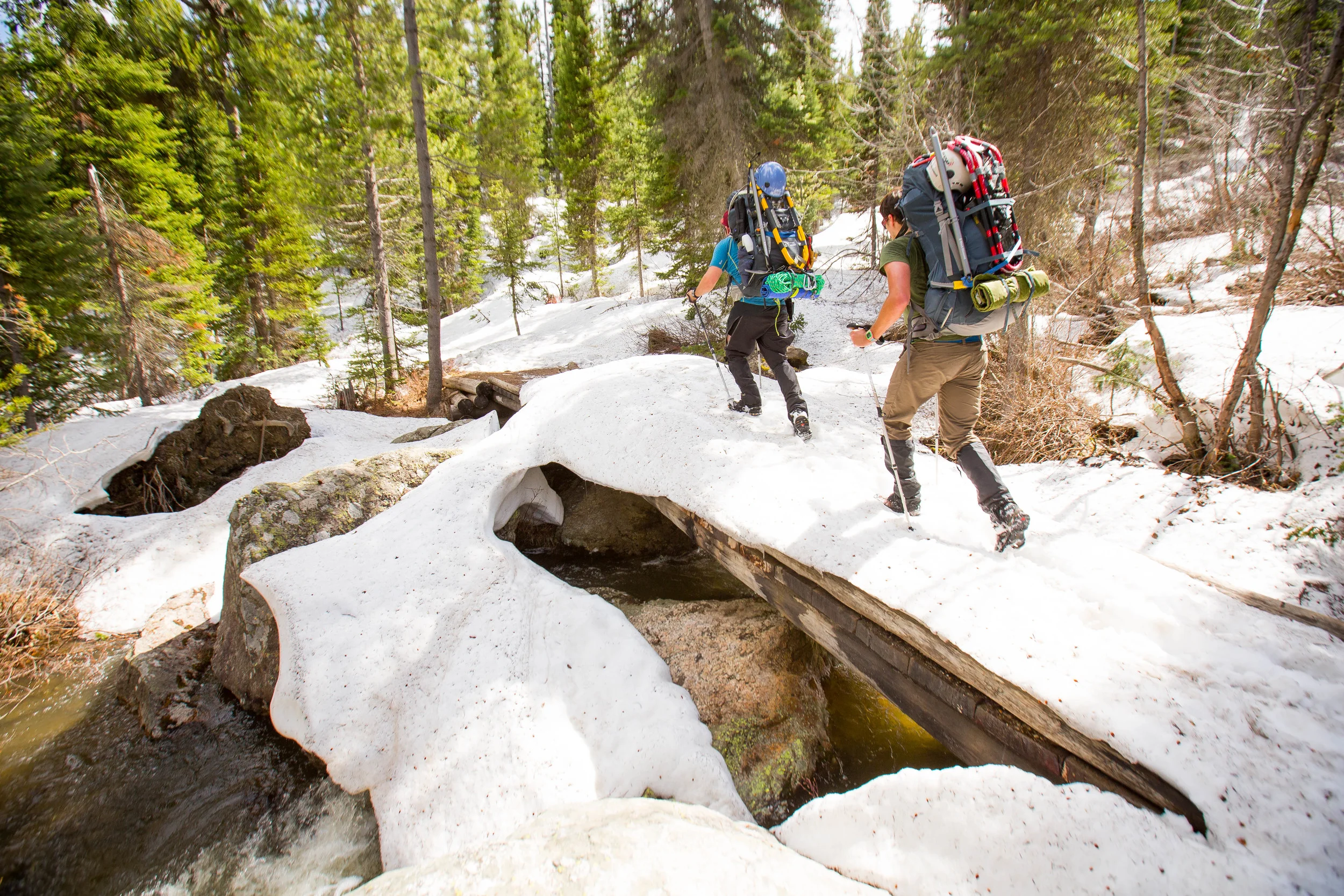 Spencer and Josh crossing a snow covered log bridge just outside the trailhead.