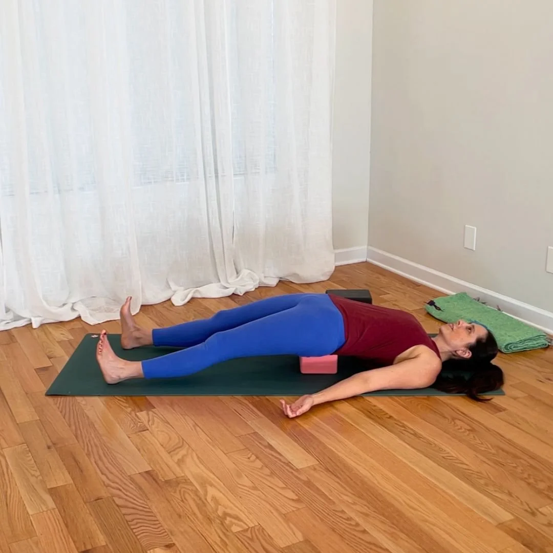 reclined hip flexor stretch with yoga block under pelvis