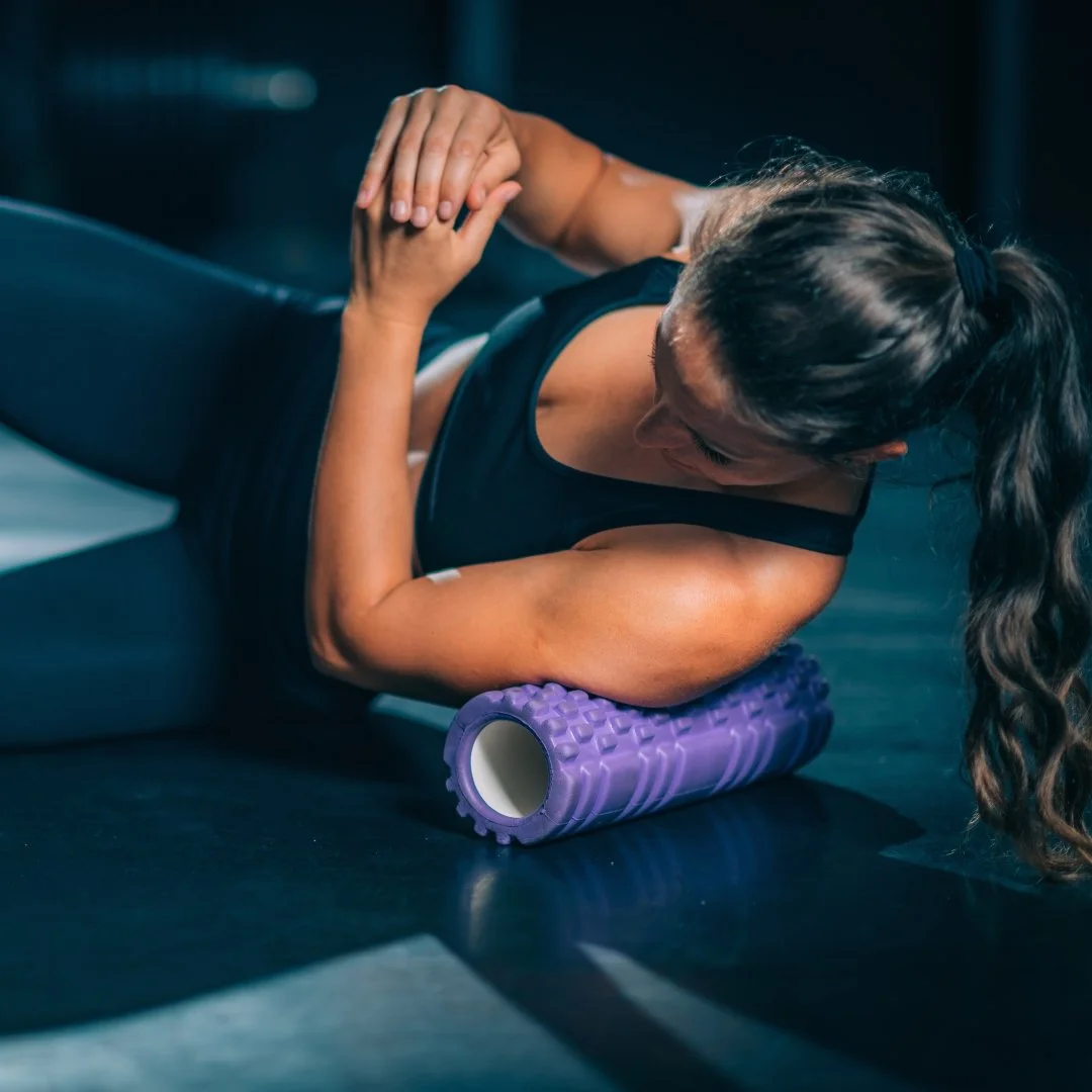 Person foam rolling their thigh as part of a warm-up to prepare for exercise.
