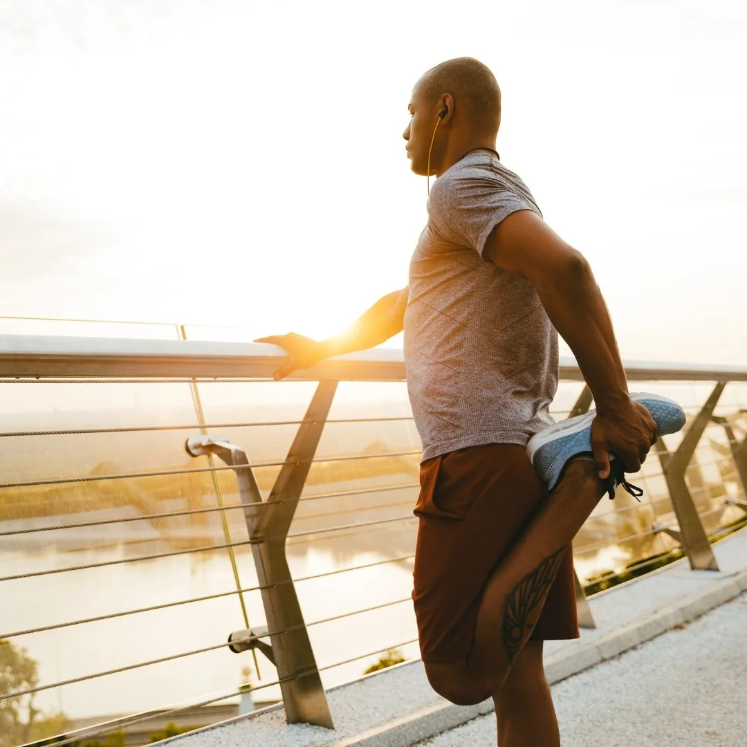 Person performing a standing quadriceps stretch to improve flexibility during a warm-up.