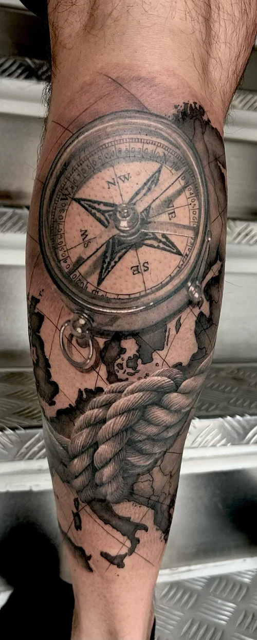 Realistic compass and rope tattoo on the calf in black and grey by Daniele Tonelli.