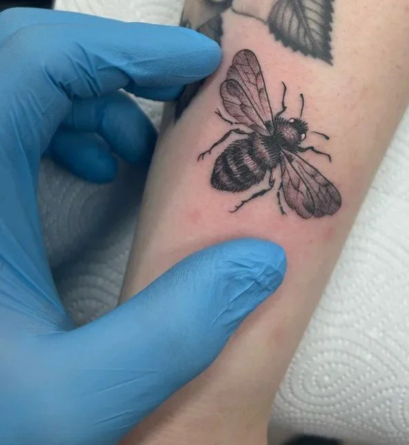Small realistic bee tattoo in black and grey by Daniele Tonelli.