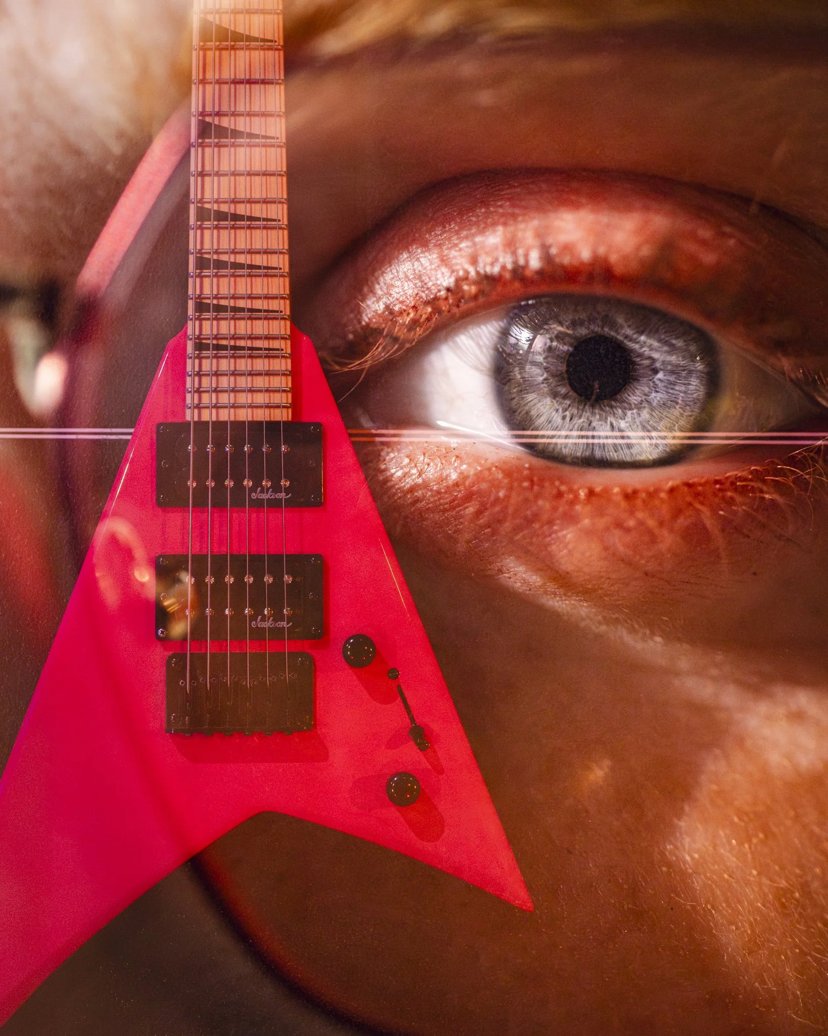 A close-up of a human eye with makeup and skin texture, superimposed with a red electric guitar.