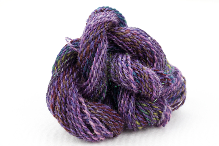 Handspun yarn. One ply is from a handpainted roving. The other ply is from the same batt as the purple yarn above.