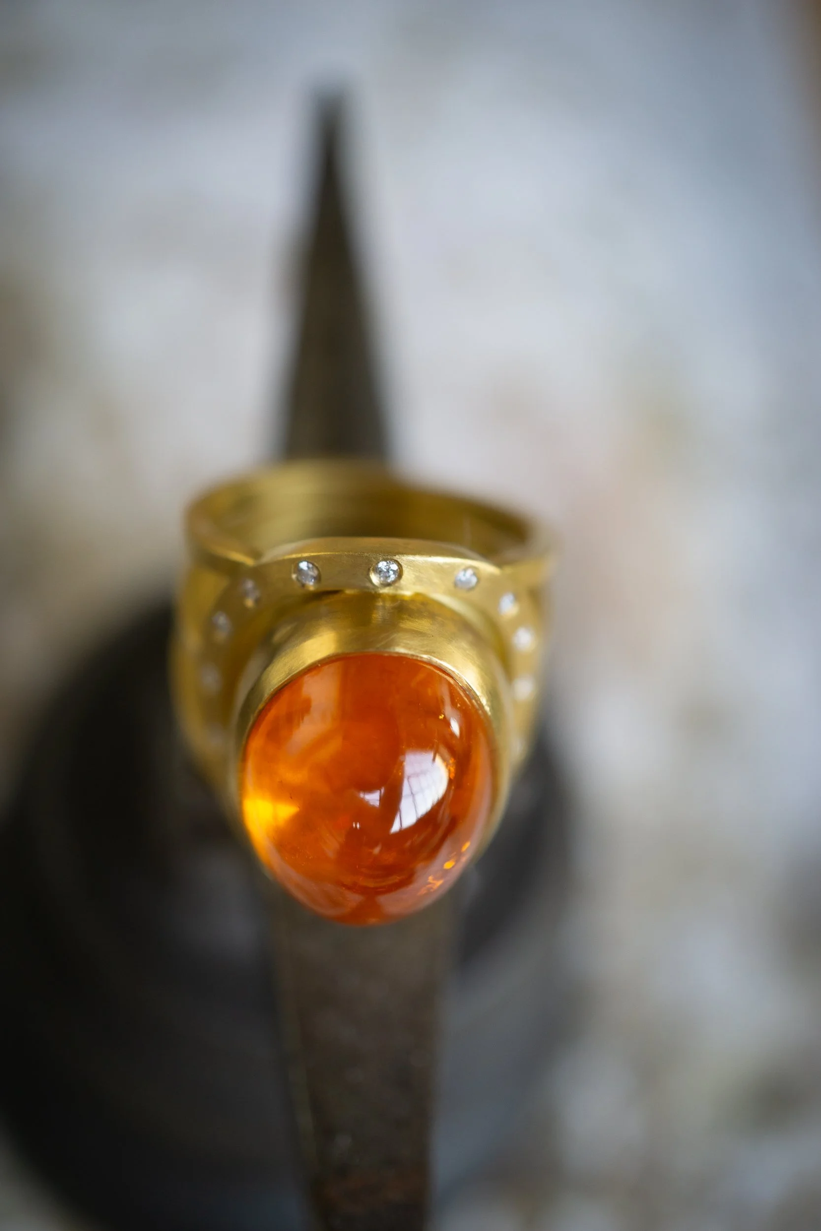 Aurora Ring in 22 karat gold, mandarin garnet, and diamond.