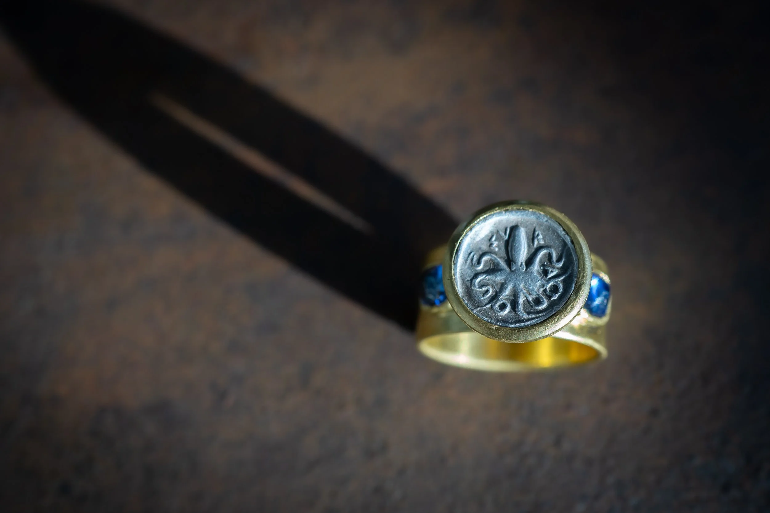 Nerithe Ring in 22-karat gold, sapphire, and antique octopus coin.