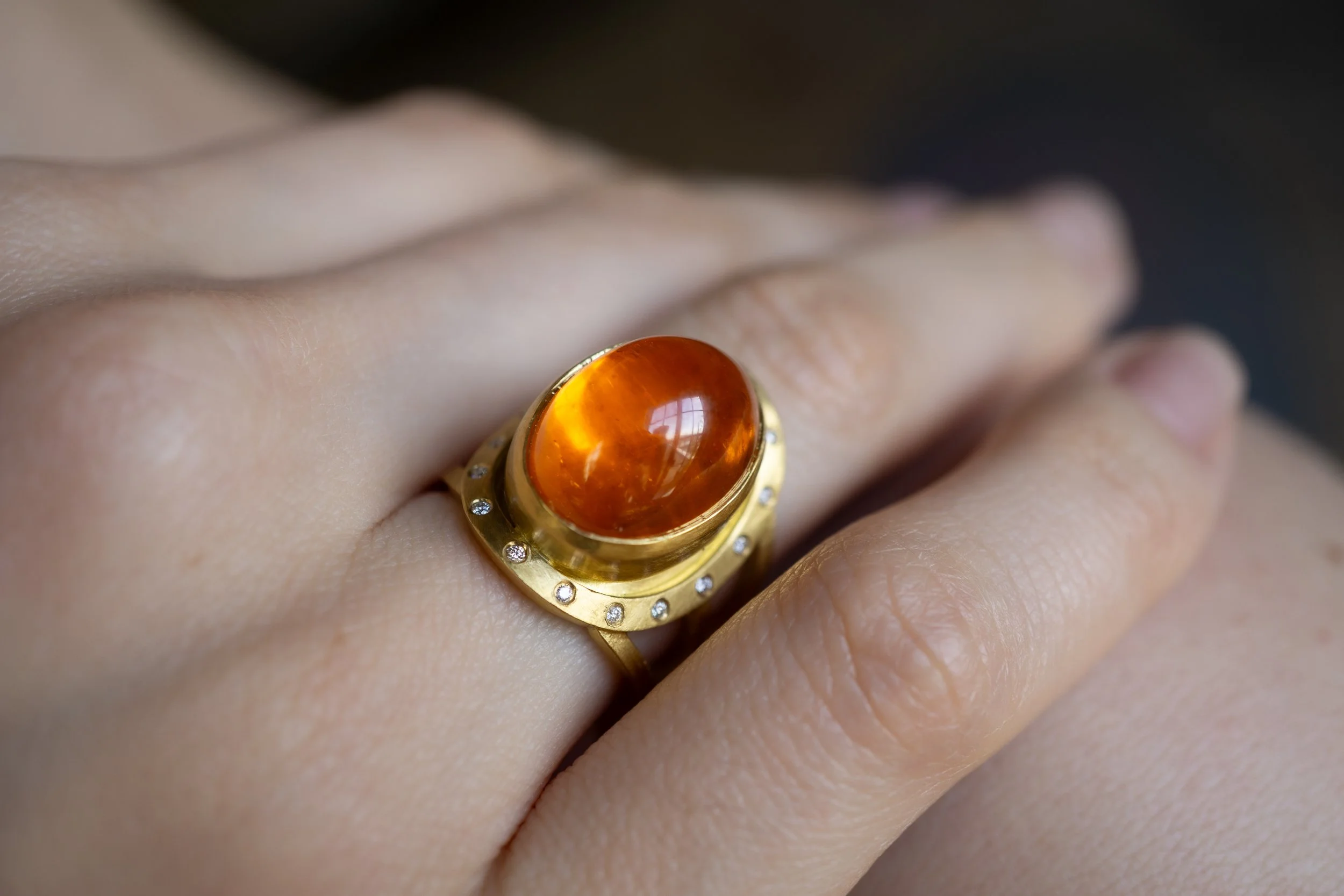 Aurora Ring on hand, on bare shoulder.